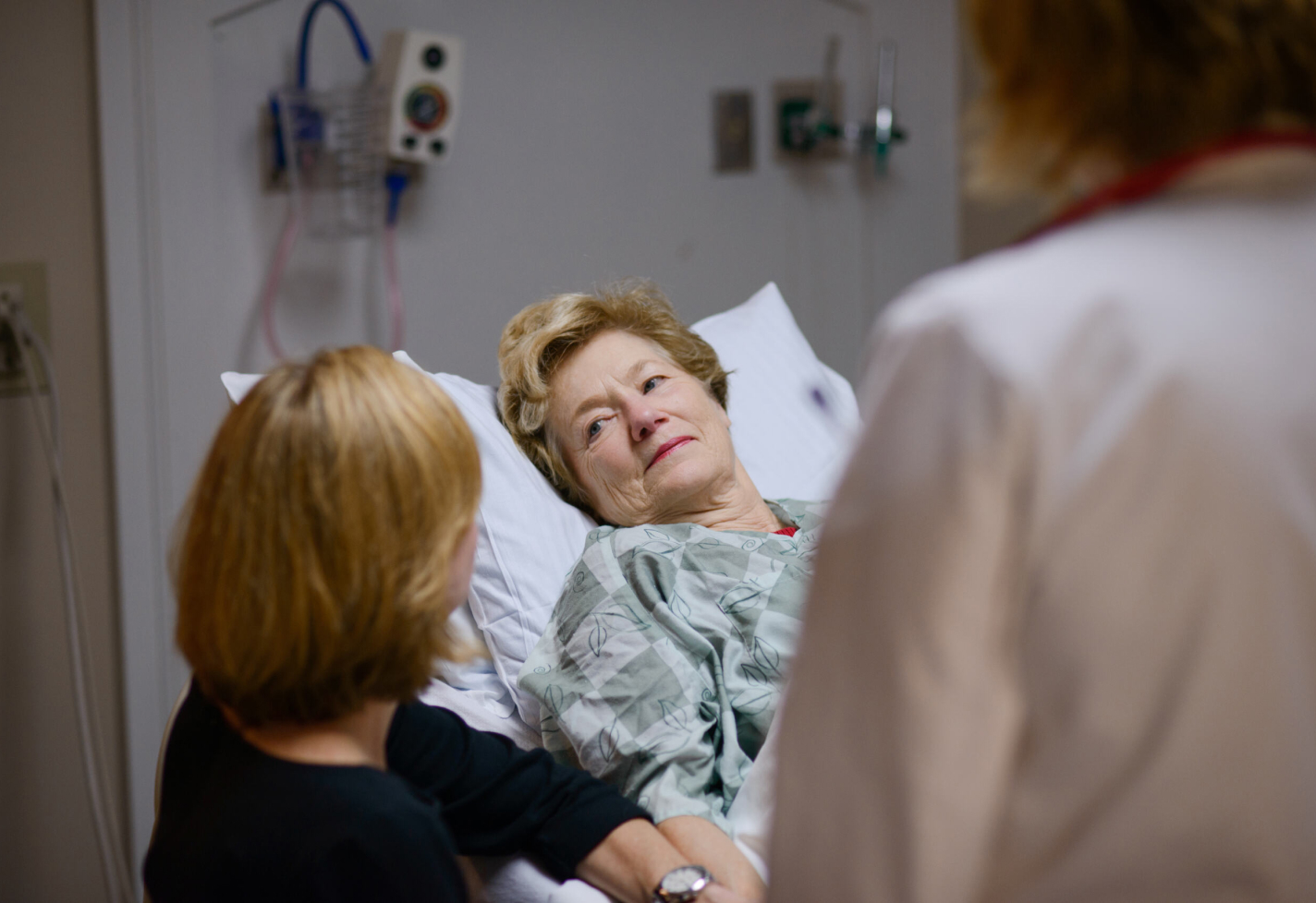 Woman lying in a hospital with team members