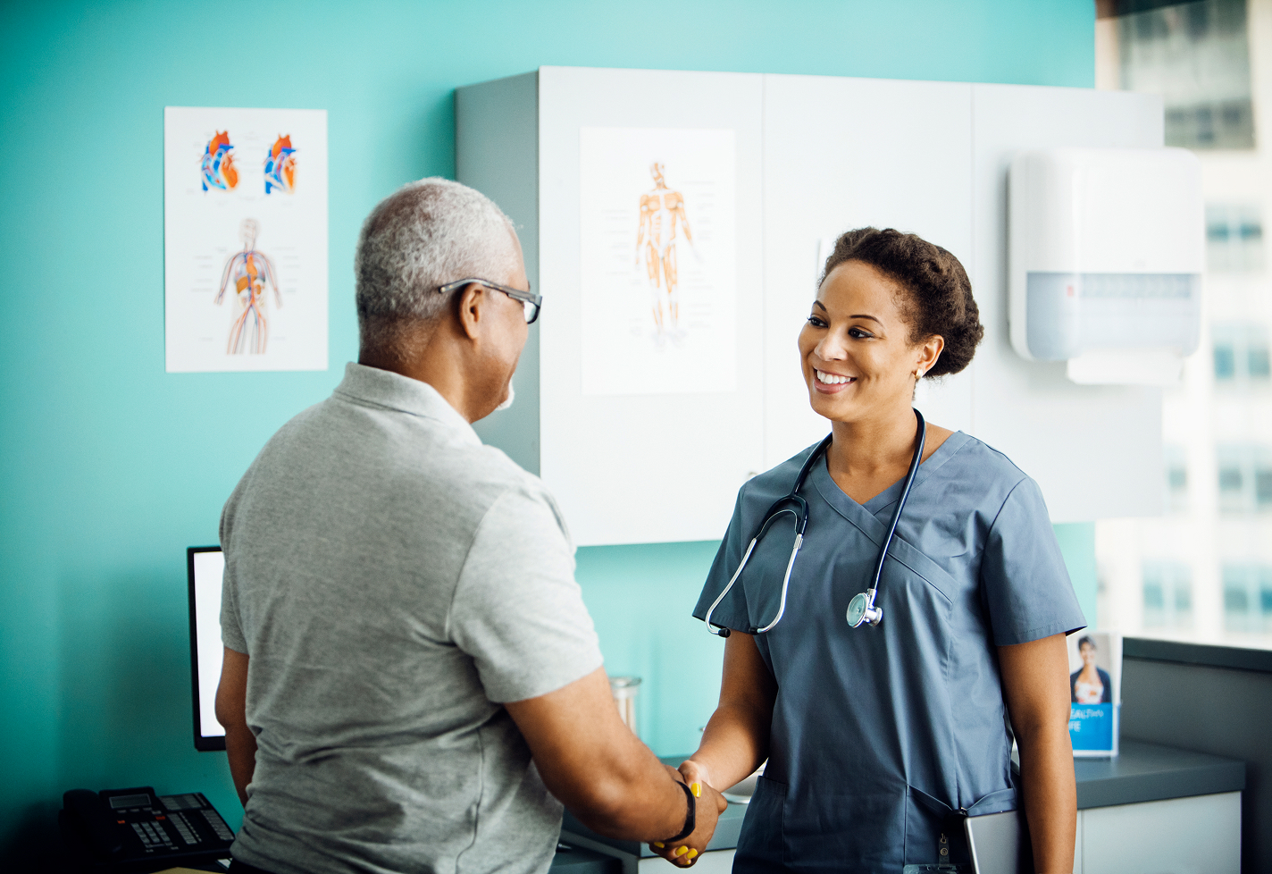 Female provider greeting a senior man in an office