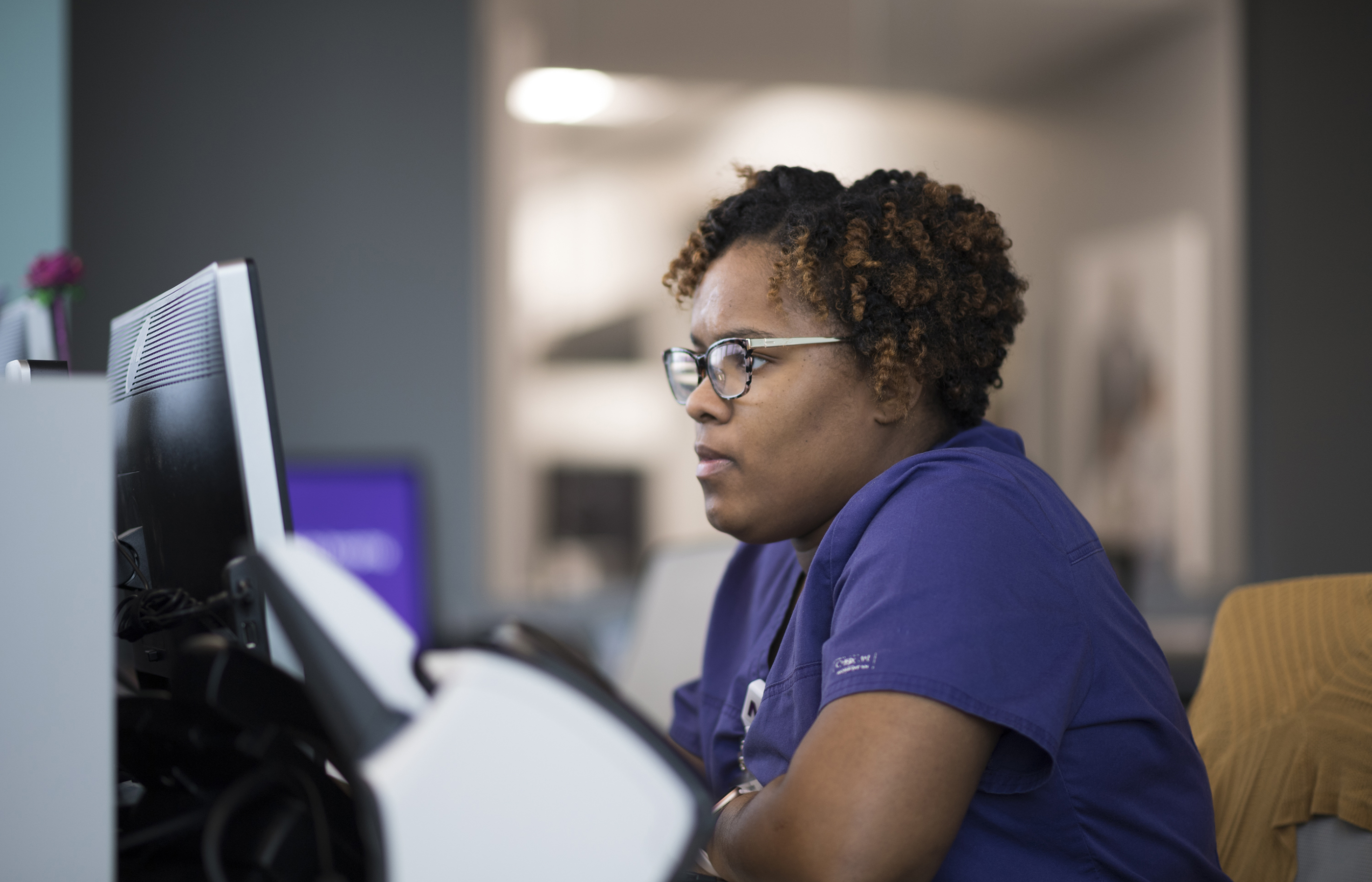 A Novant Health nurse is sitting at a computer reviewing information. 