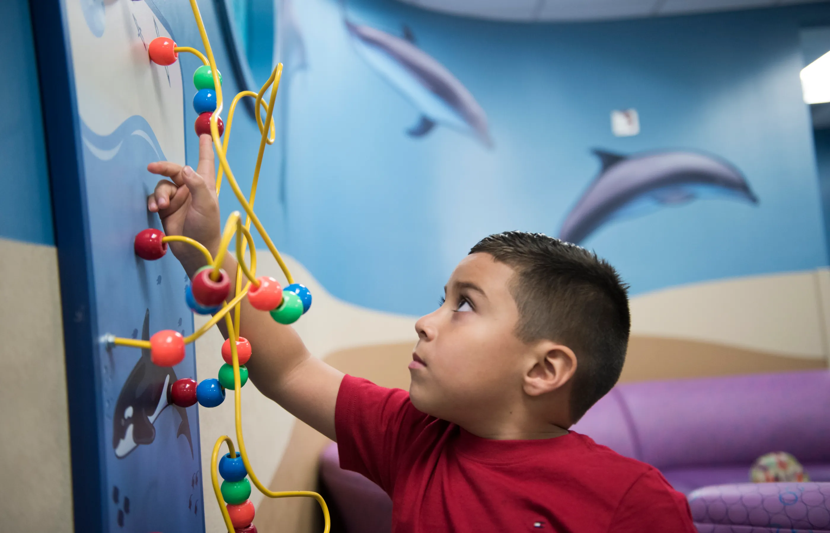 A young boy is playing with toys in a clinic lobby. 