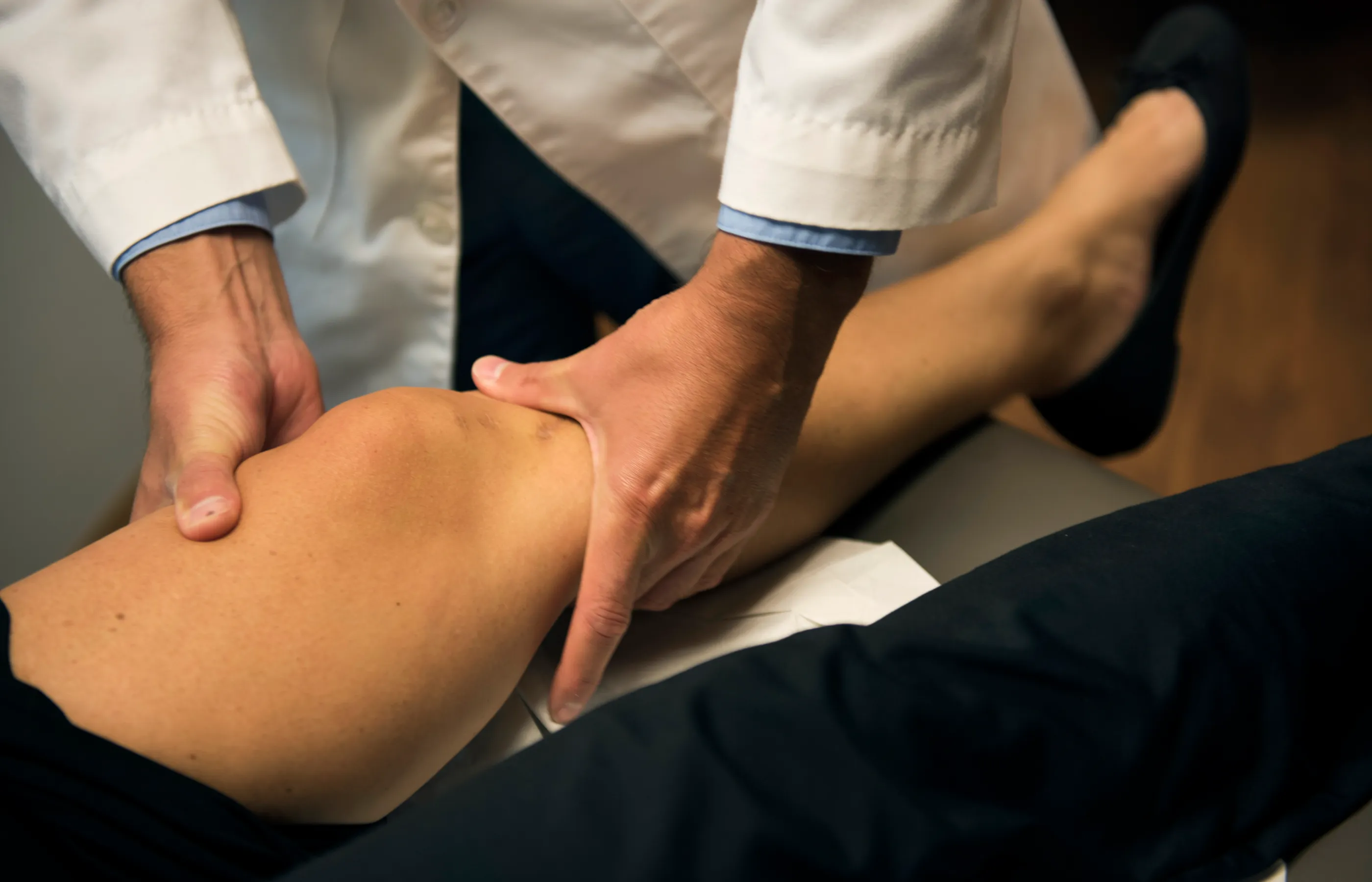 A Novant Health provider is examining a patient's knee. 