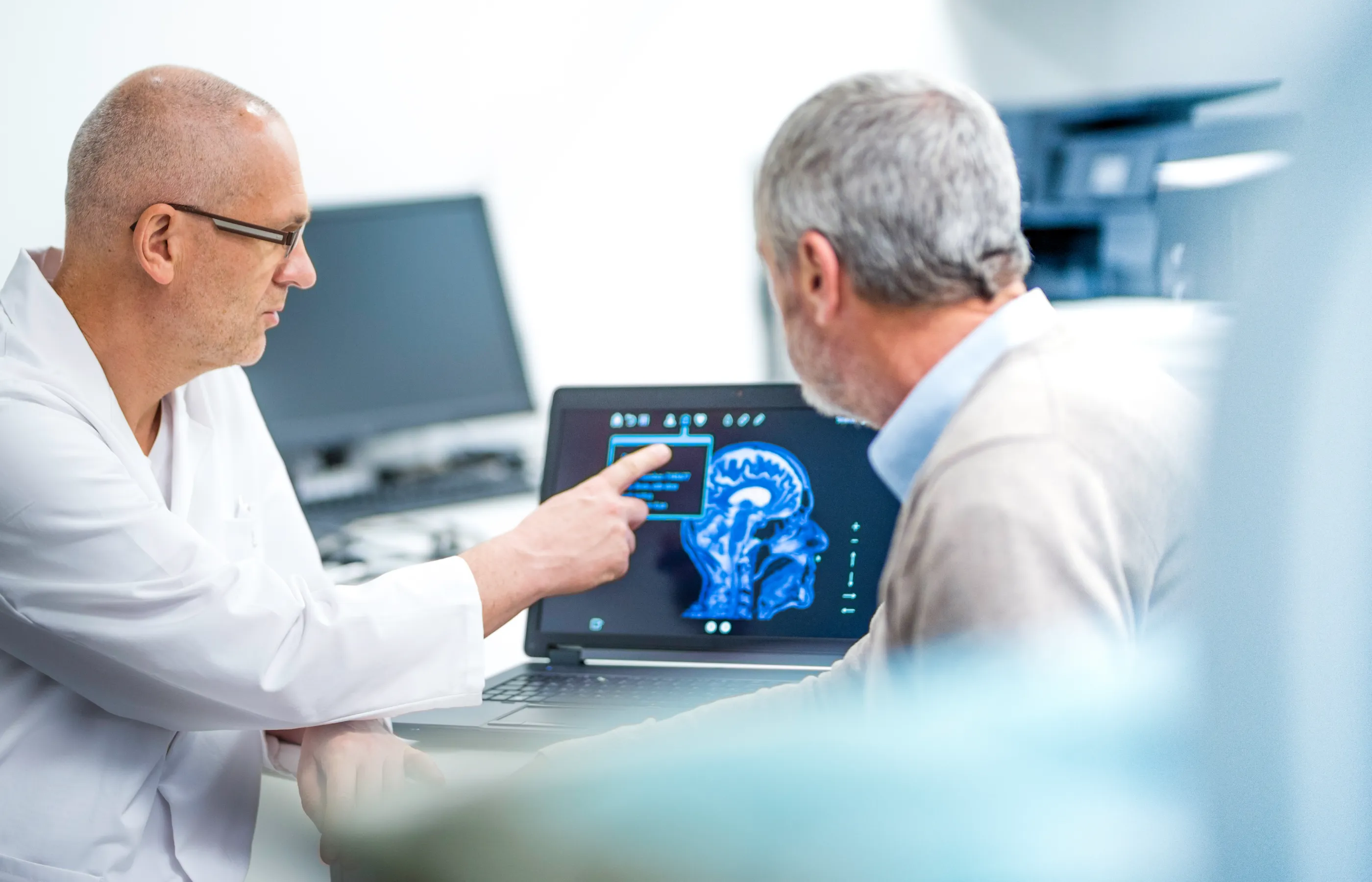 A health care provider is reviewing a brain scan with a patient. 