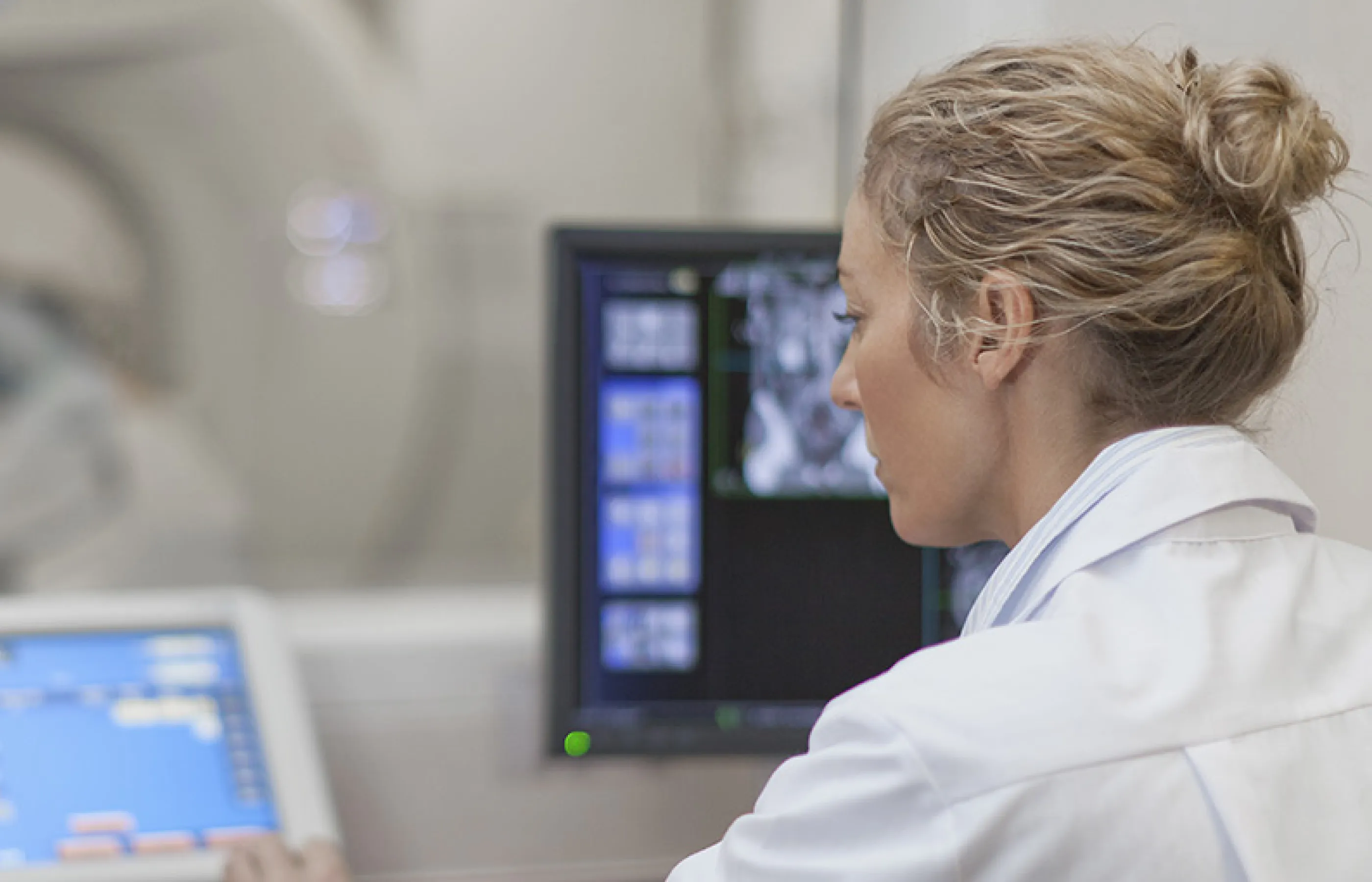 A Novant Health team member is sitting operating computers to complete a patient's imaging scan. 