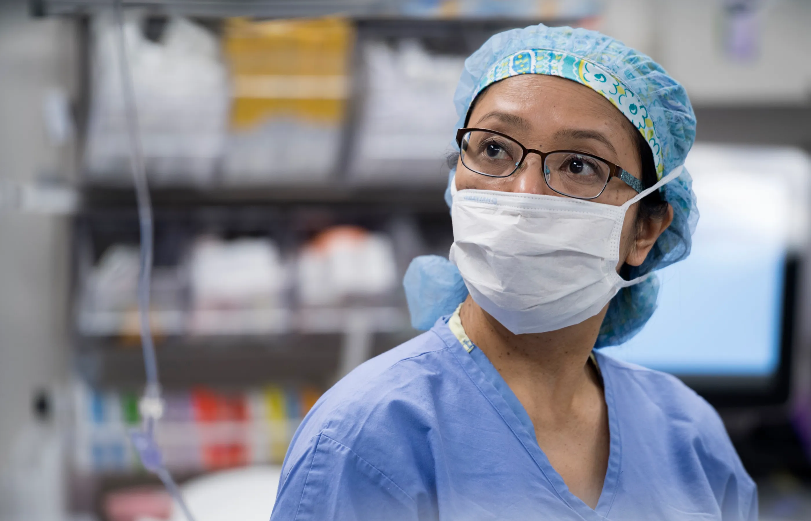 A Novant Health team member is in a hospital room dress in personal protective equipment (PPE), including a mask. 