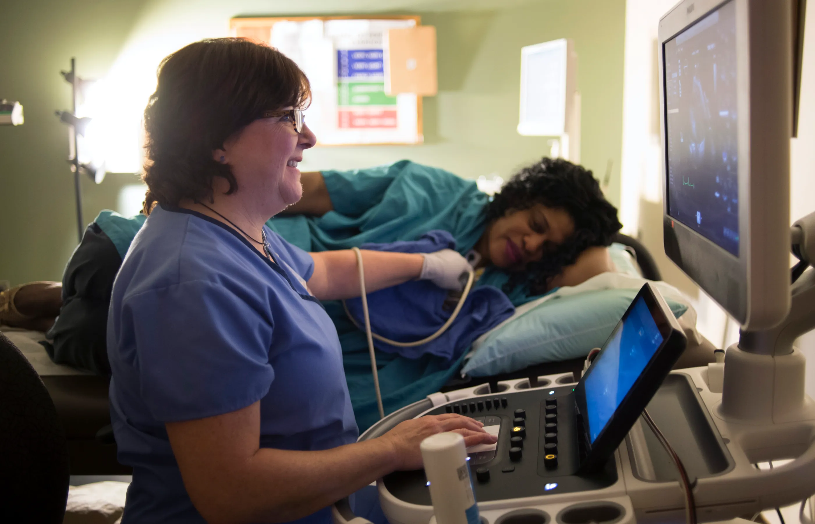 A Novant Health imaging tech is taking an ultrasound of a patient's heart as they lay on a table. 