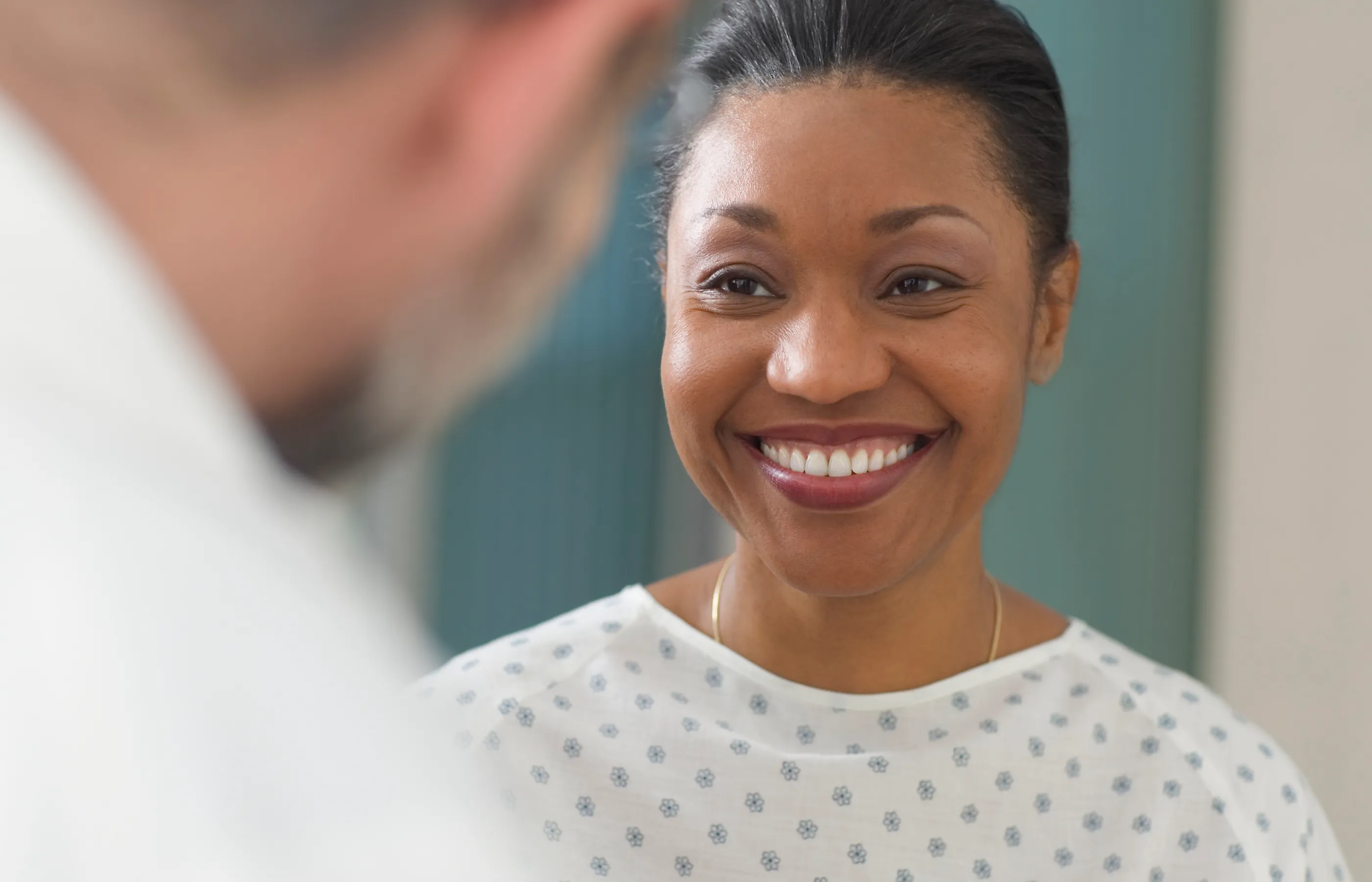 Smiling patient in a gown with a physician