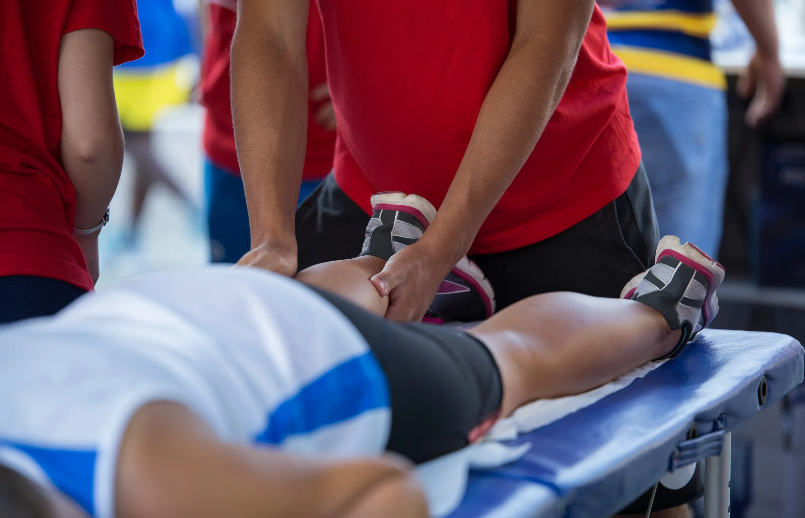 A team member is assisting a patient at an athletic event. 