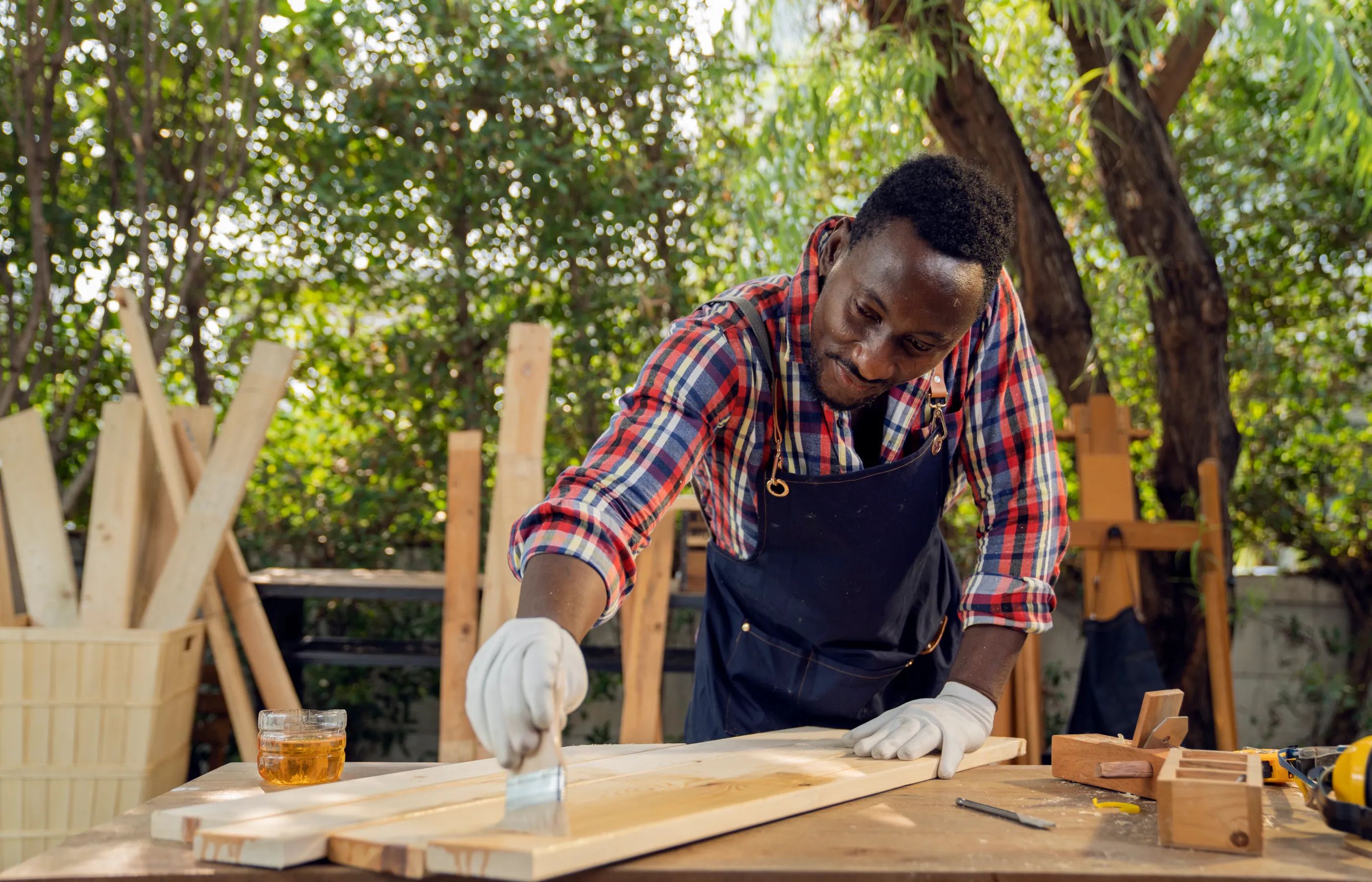 A man is wood working outside on a beautiful day. 