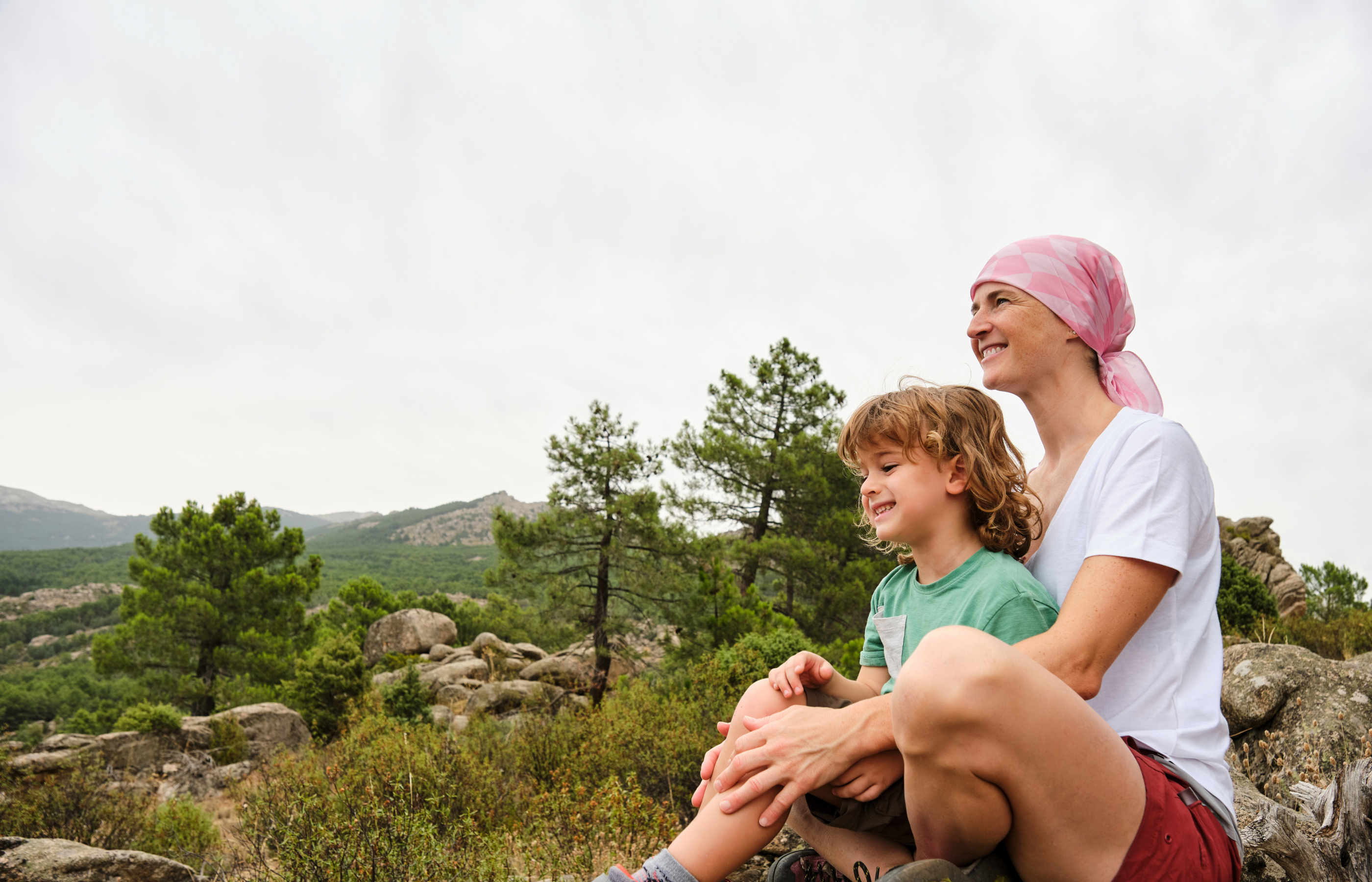 A mother and her son sitting outside on a clear day.