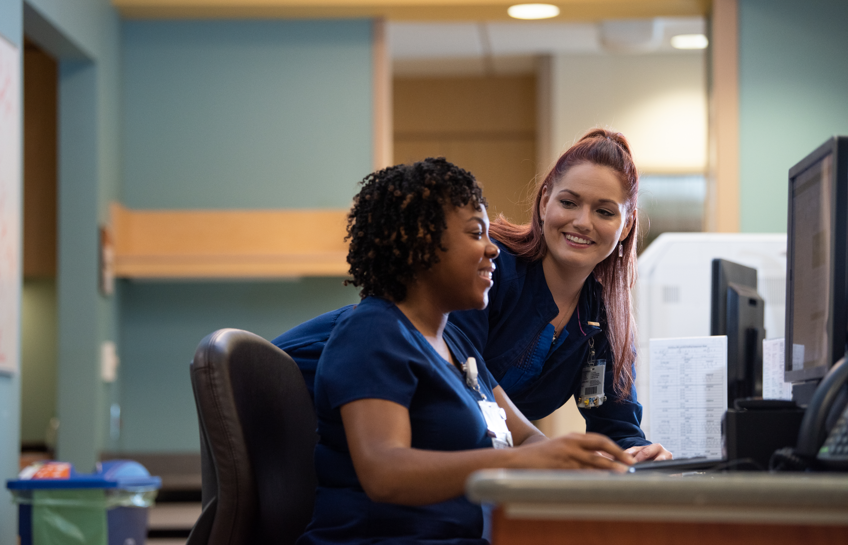 Two Registered Nurses working at computer in the hospital 