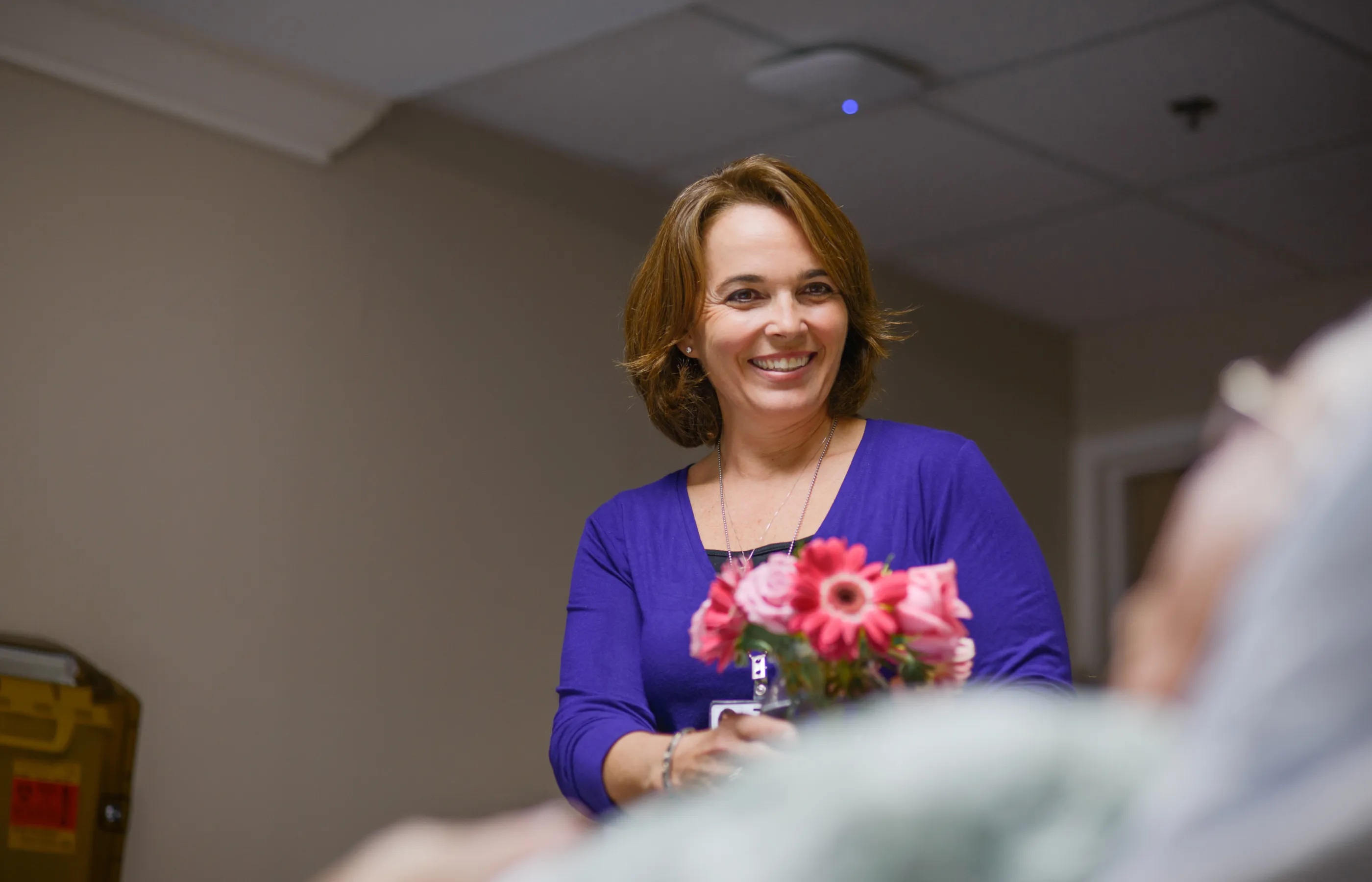 A team member is delivering flowers to a patient.