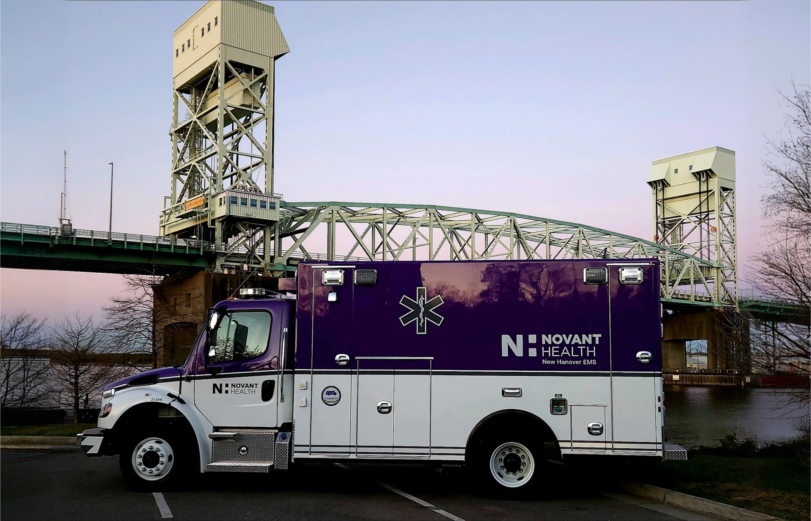 EMS community care truck parked in front of a bridge.