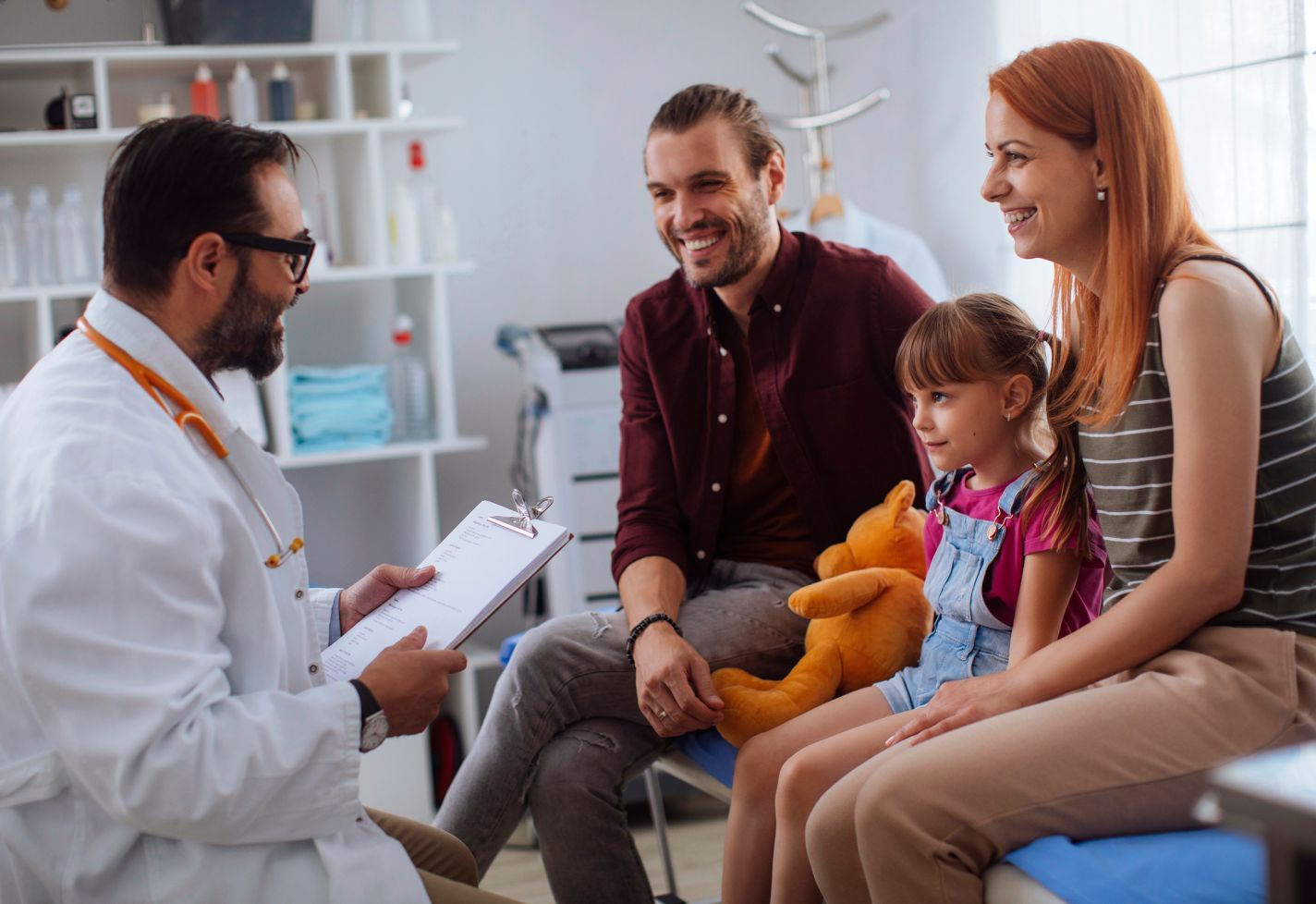 A family sitting in a doctor's office speaking with a male doctor.