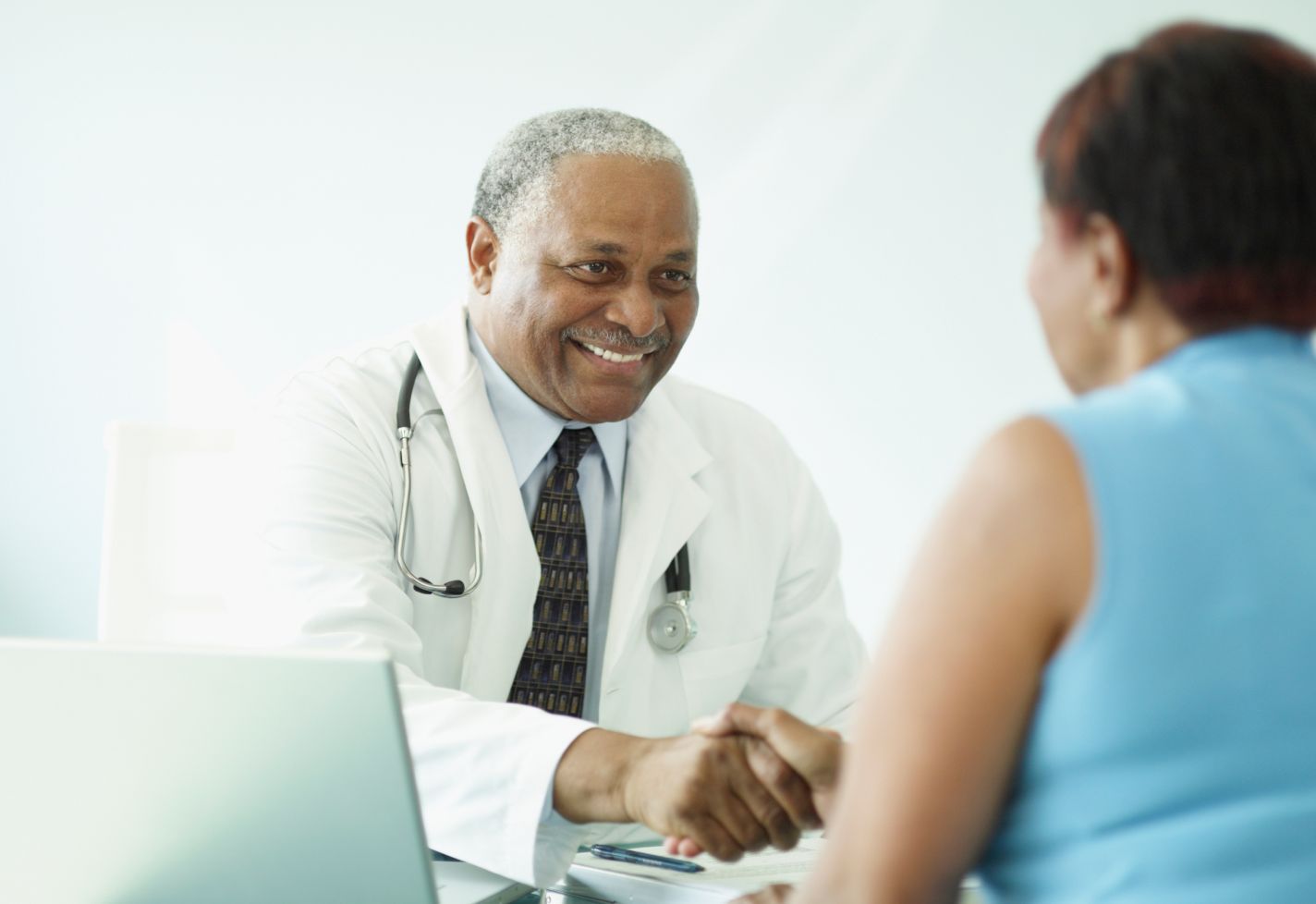 A male doctor sitting and talking with a patient.