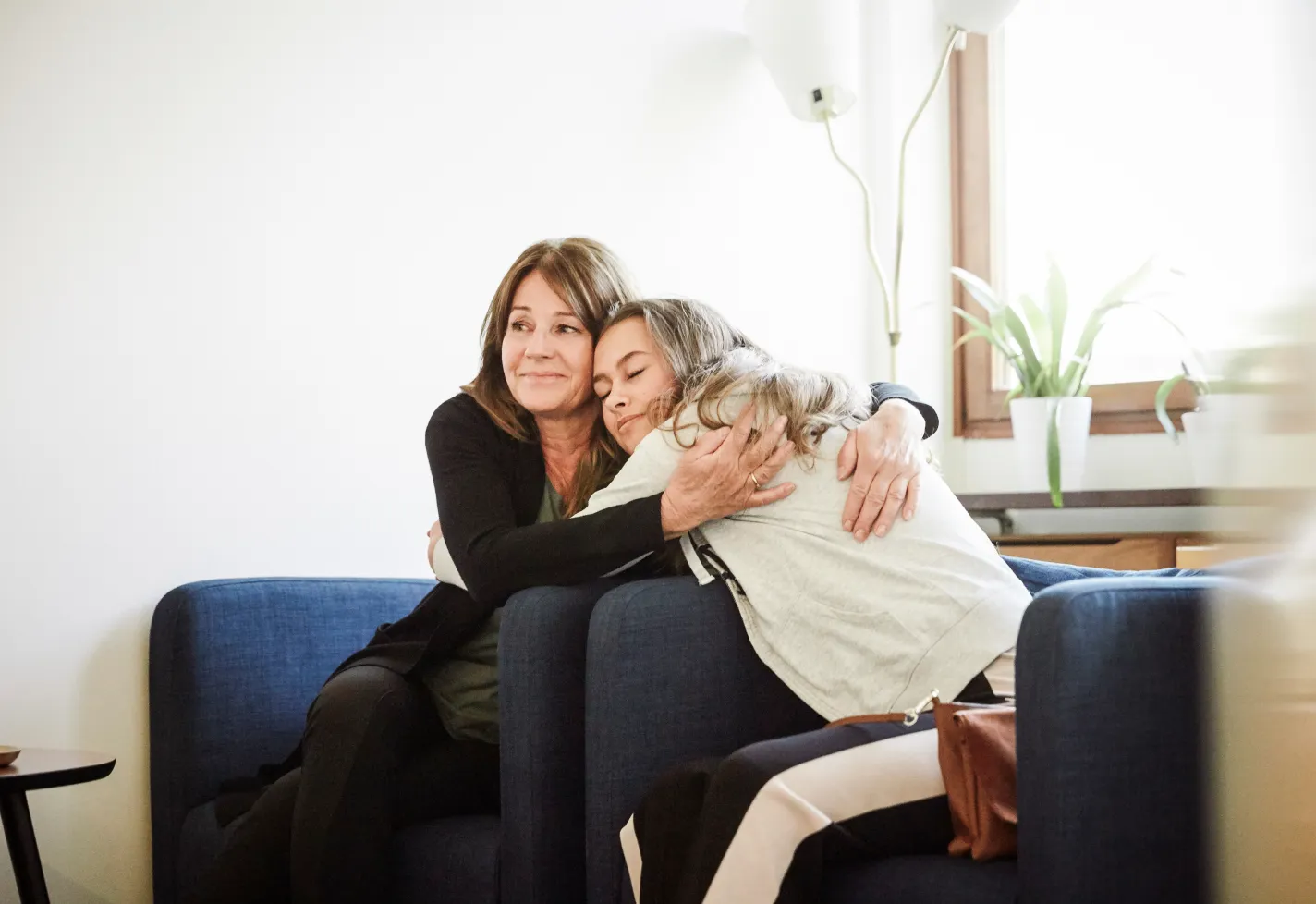 Loving mother hugging her teenage daughter during a therapy session