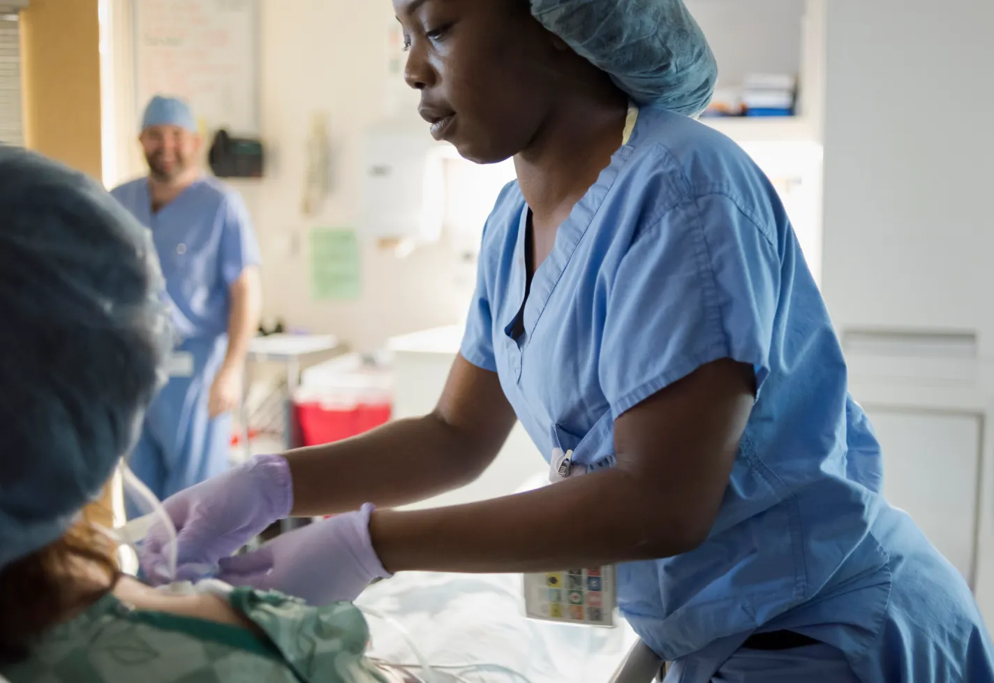 Nurse prepping a surgical patient as a physician oversees 
