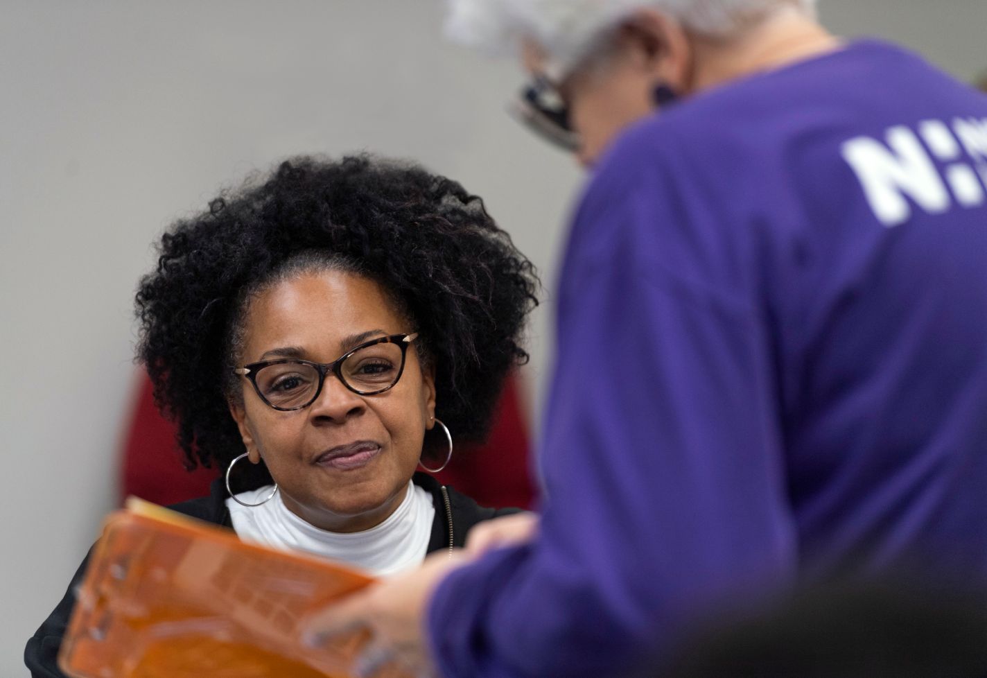 A woman looks at a clipboard held by a Novant Health team member.