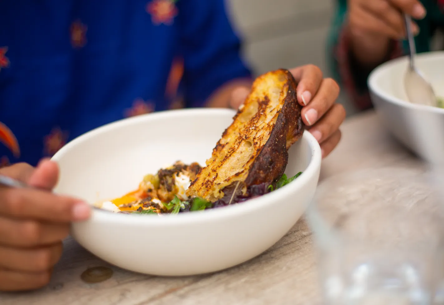 A bowl of salad with toasted bread. 