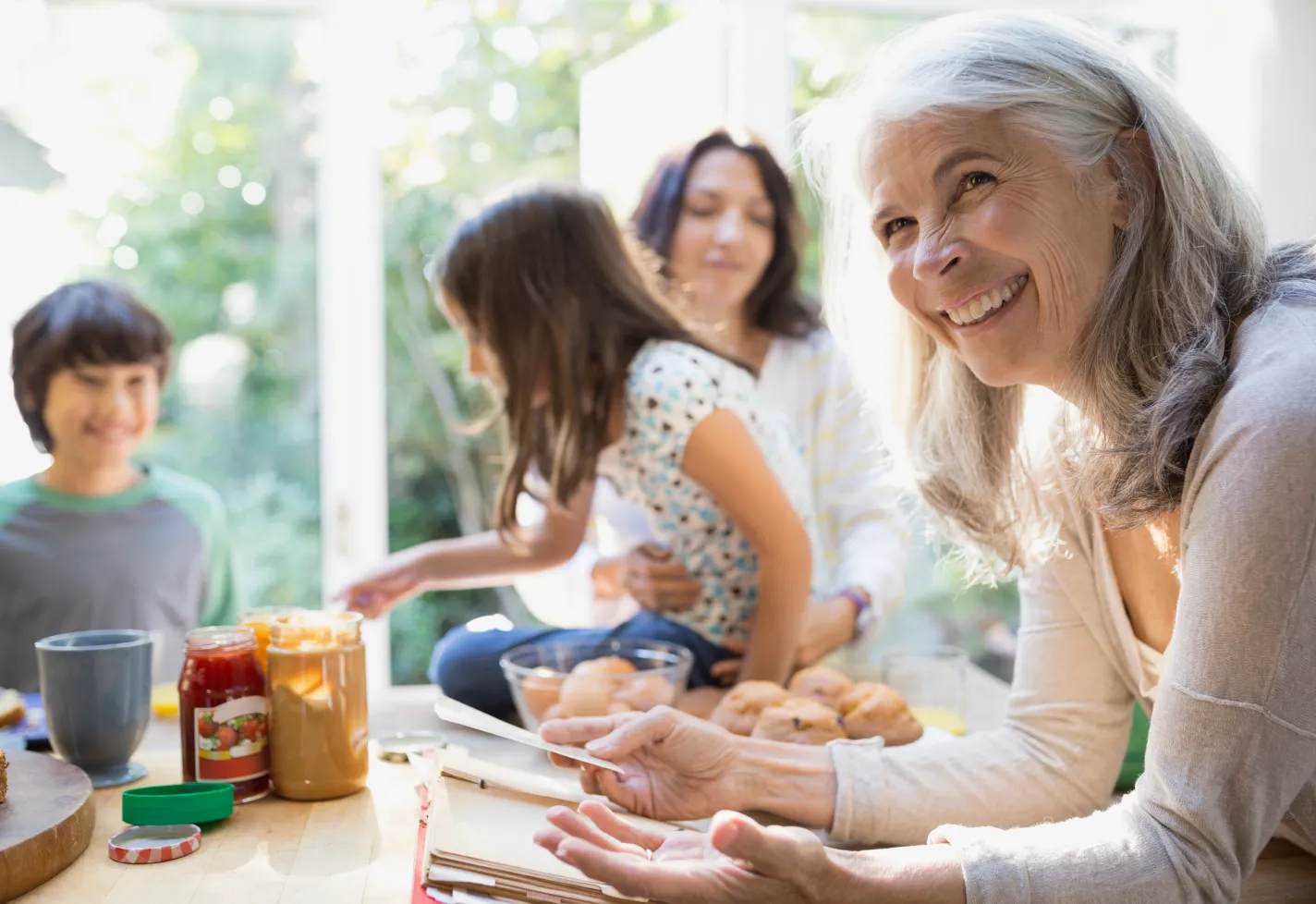 Happy grandmother, daughter and grandchildren having fun while baking in the kitchen