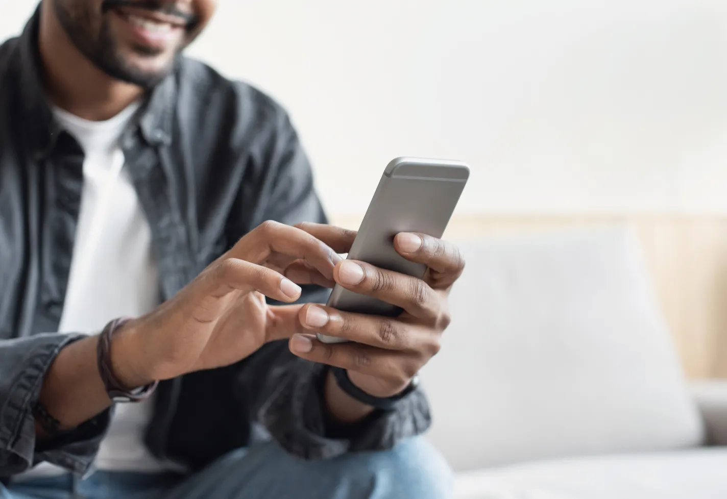 A man is holding and reviewing information on his smartphone. 