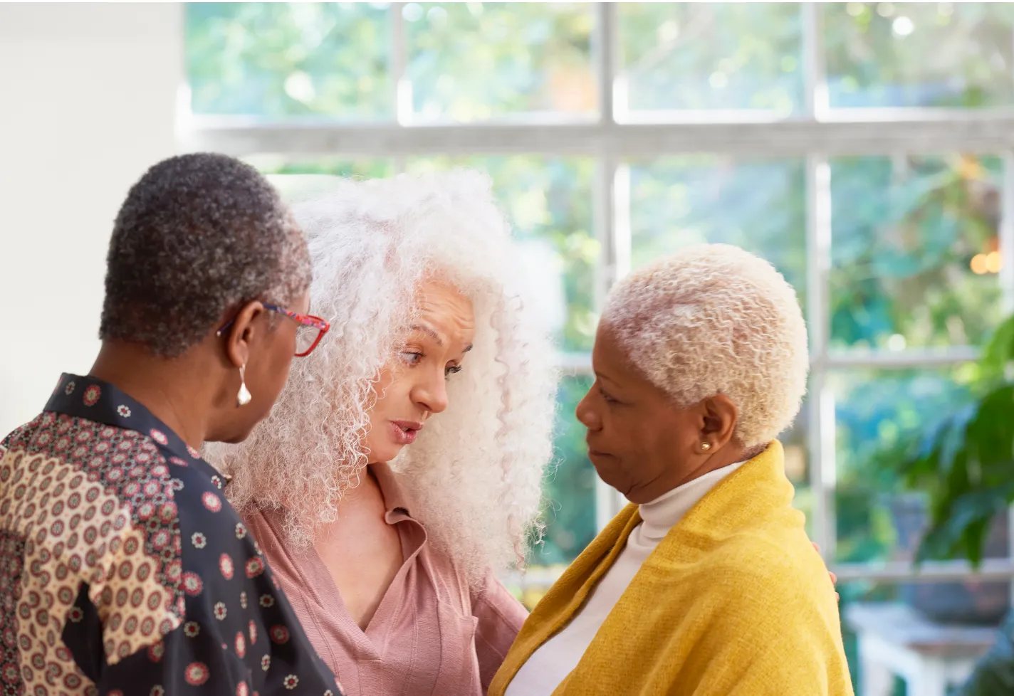 Three senior women friends discussing something important