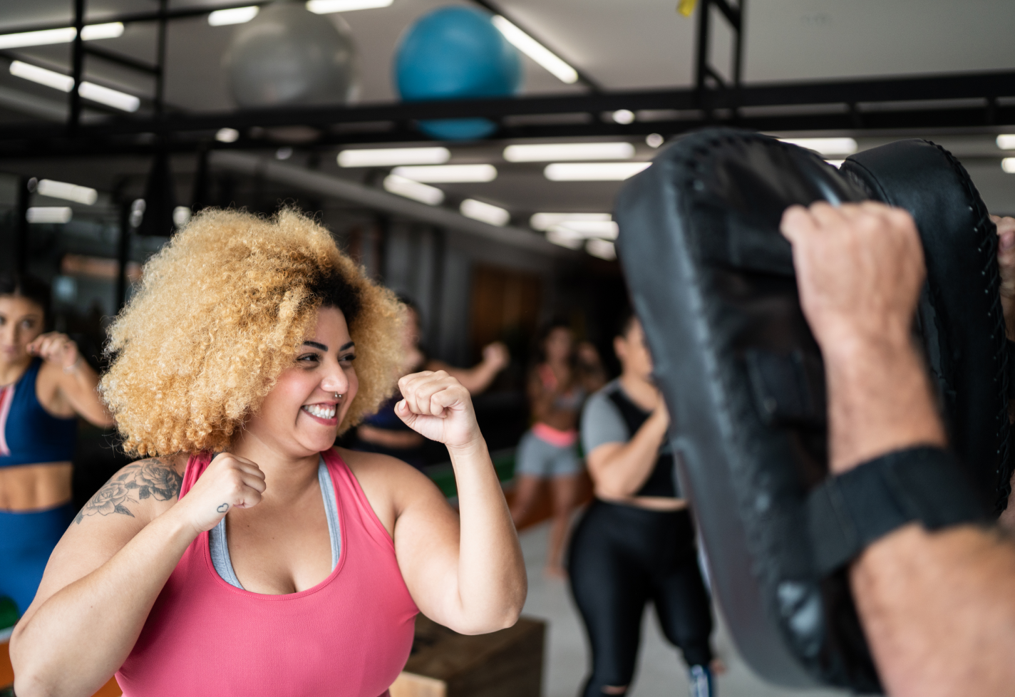 Smiling woman in boxing workout class.