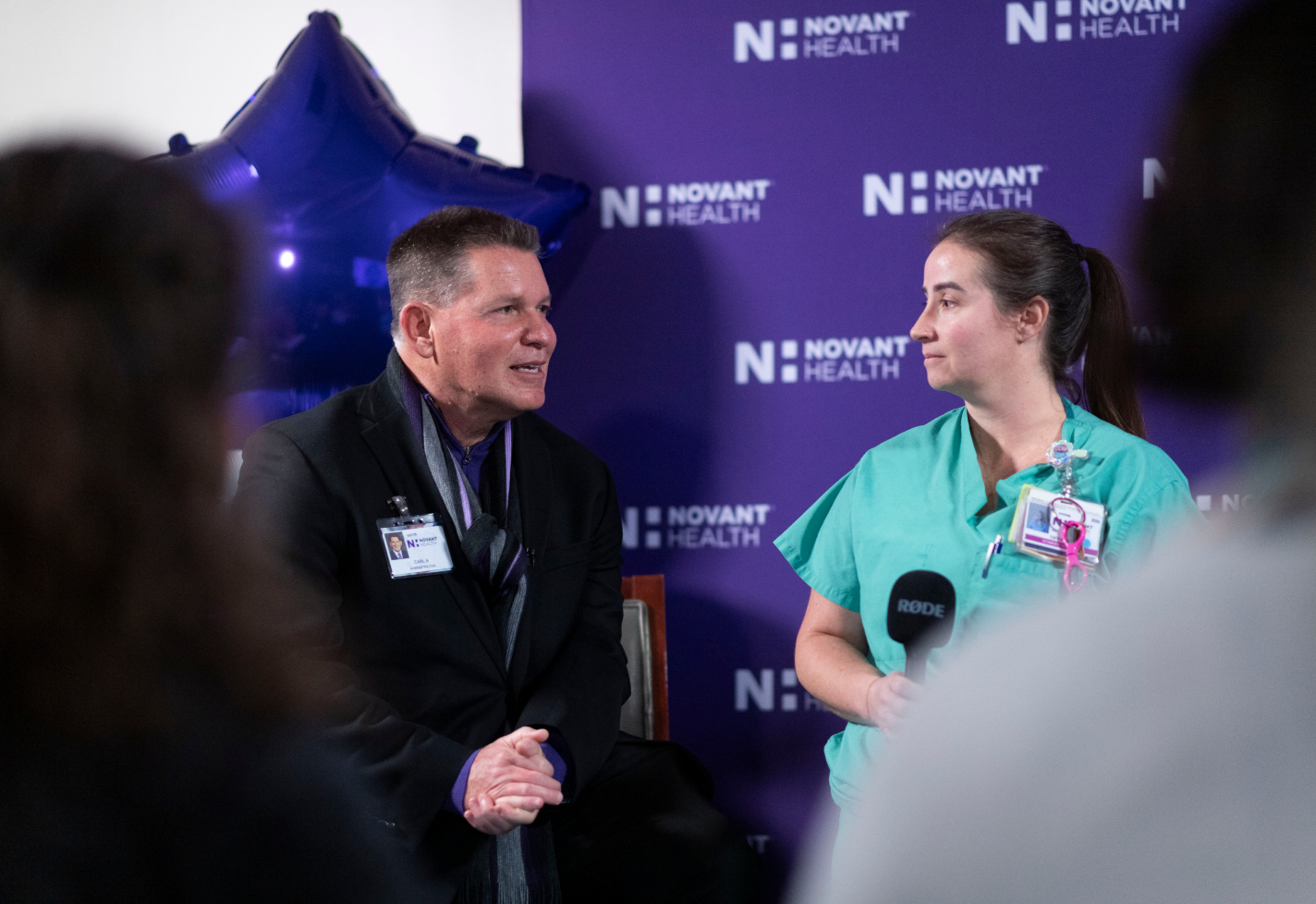 Carl Amato and a nurse speaking at a live meeting.