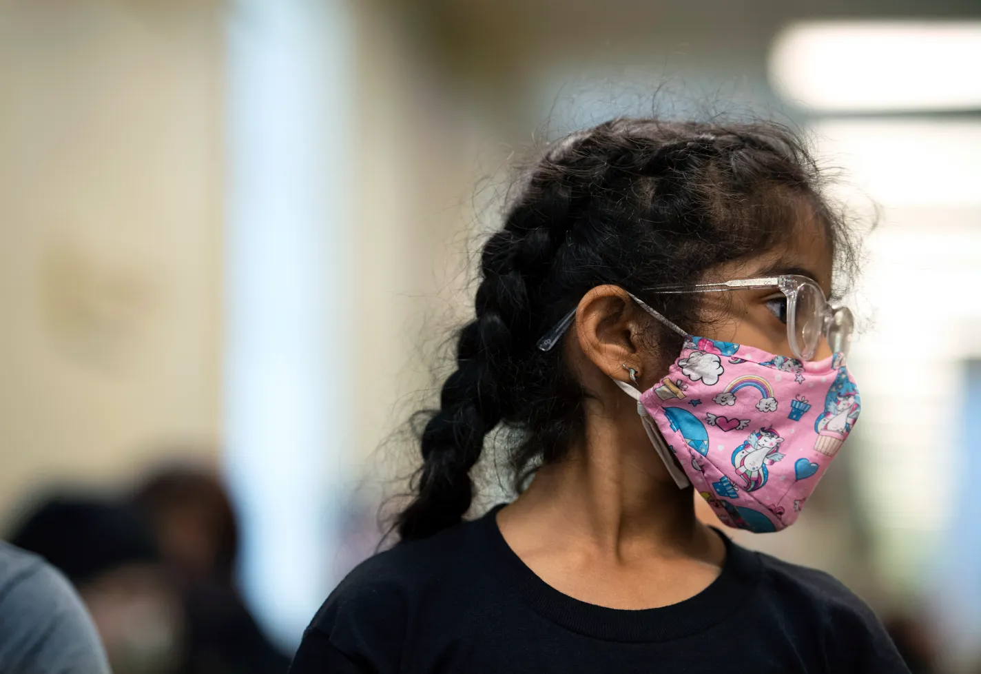 A young girl is in a Novant Health clinic wearing a face mask. 