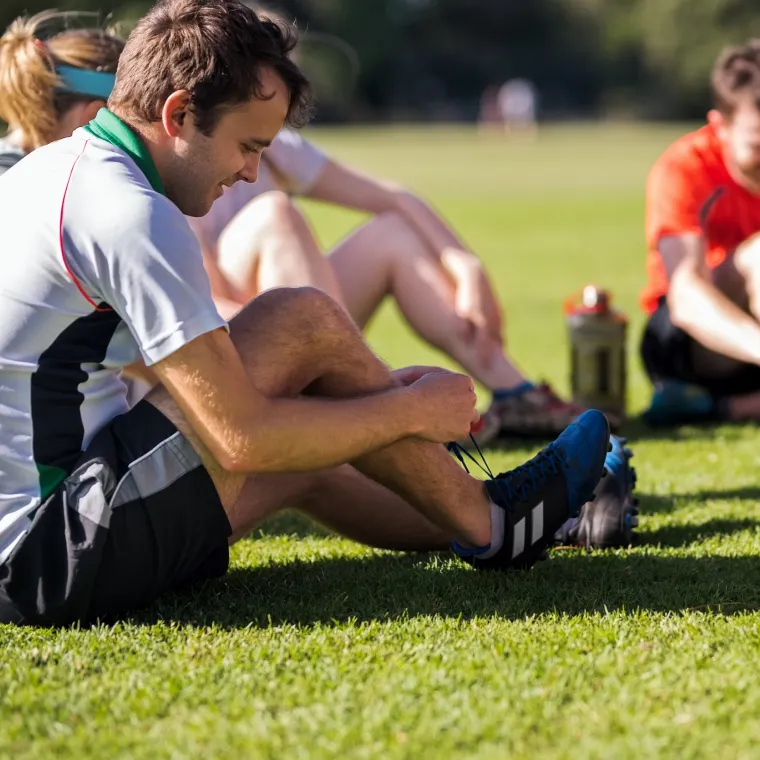 Soccer player tying his shoe before a match.