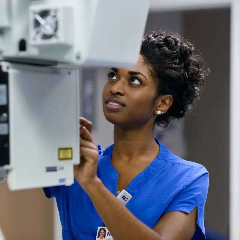 A Novant Health team member is operating a machine to capture an patients imaging scan. 