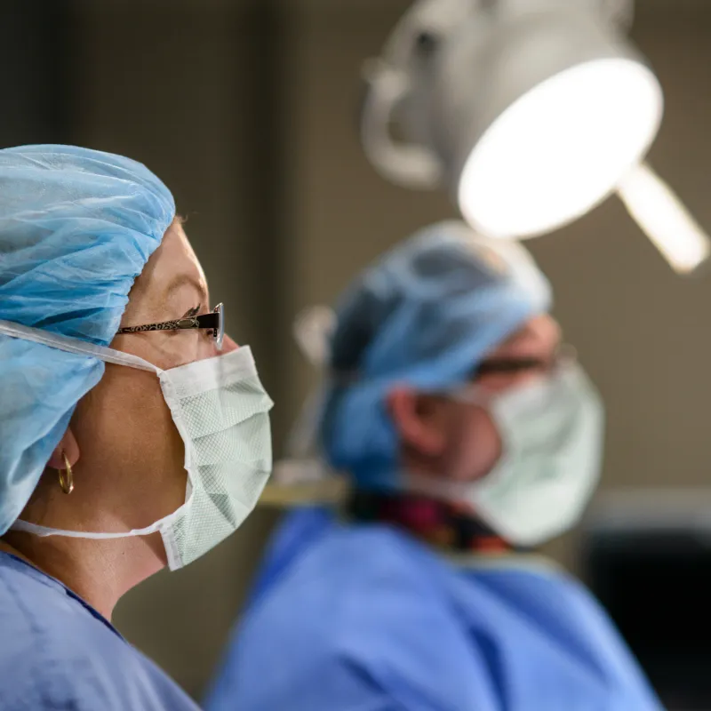 Two masked surgeons in the operating room preparing for surgery. 