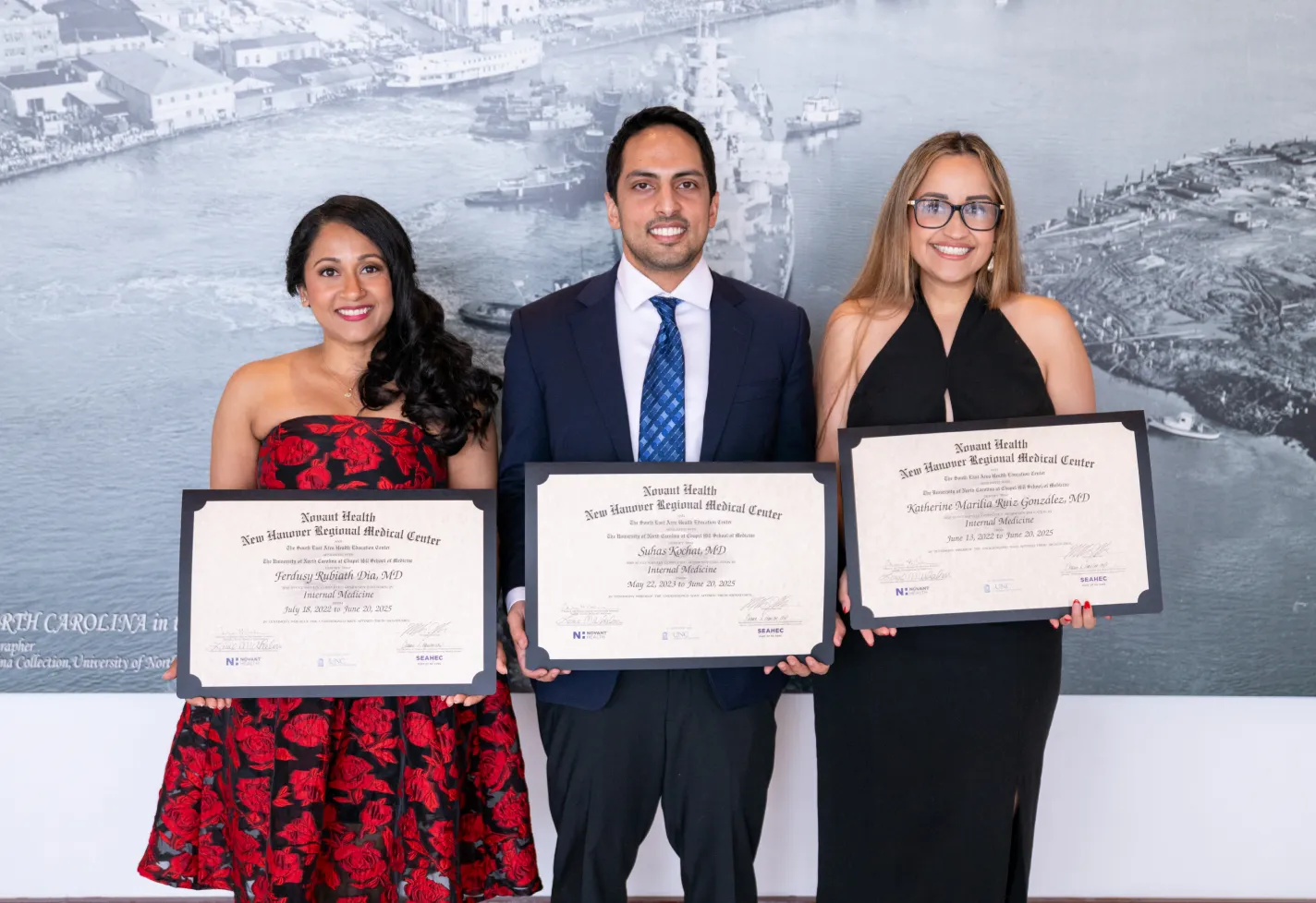 Three Novant Health internal medicine residents holding their diplomas at graduation
