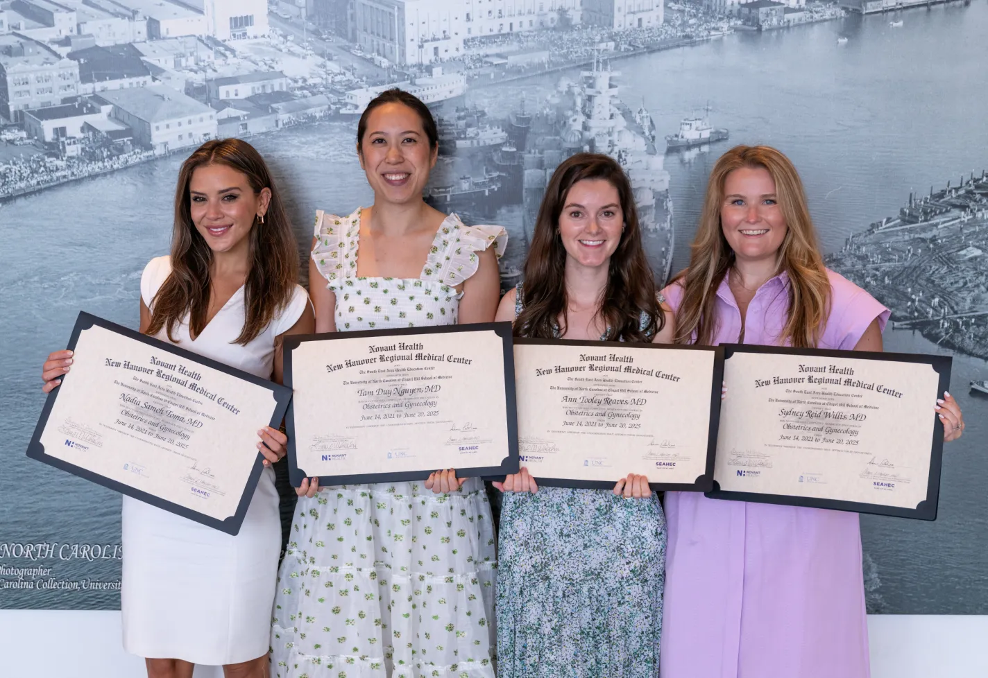 Four Novant Health ob-gyn residents holding their diplomas at graduation