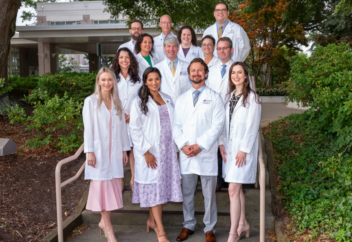 Wilmington surgery residents and faculty in white coats at graduation
