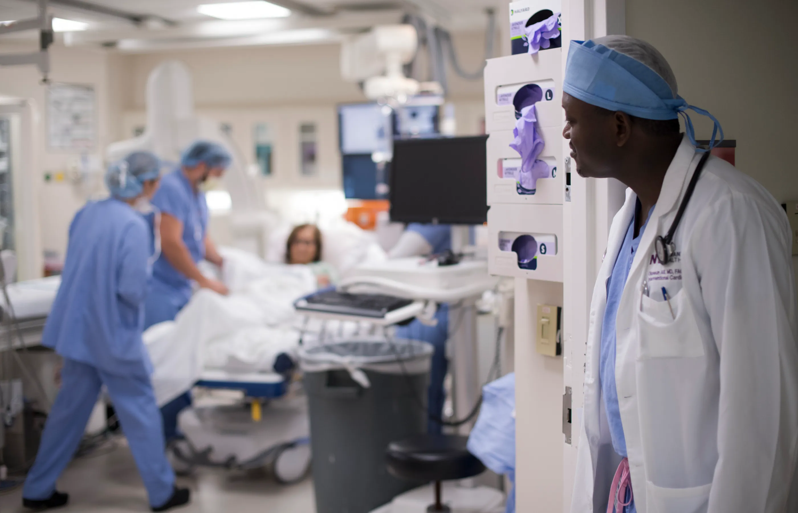 Dr. Alli Is looking inside of an operating room as team members prepare a patient for surgery. 