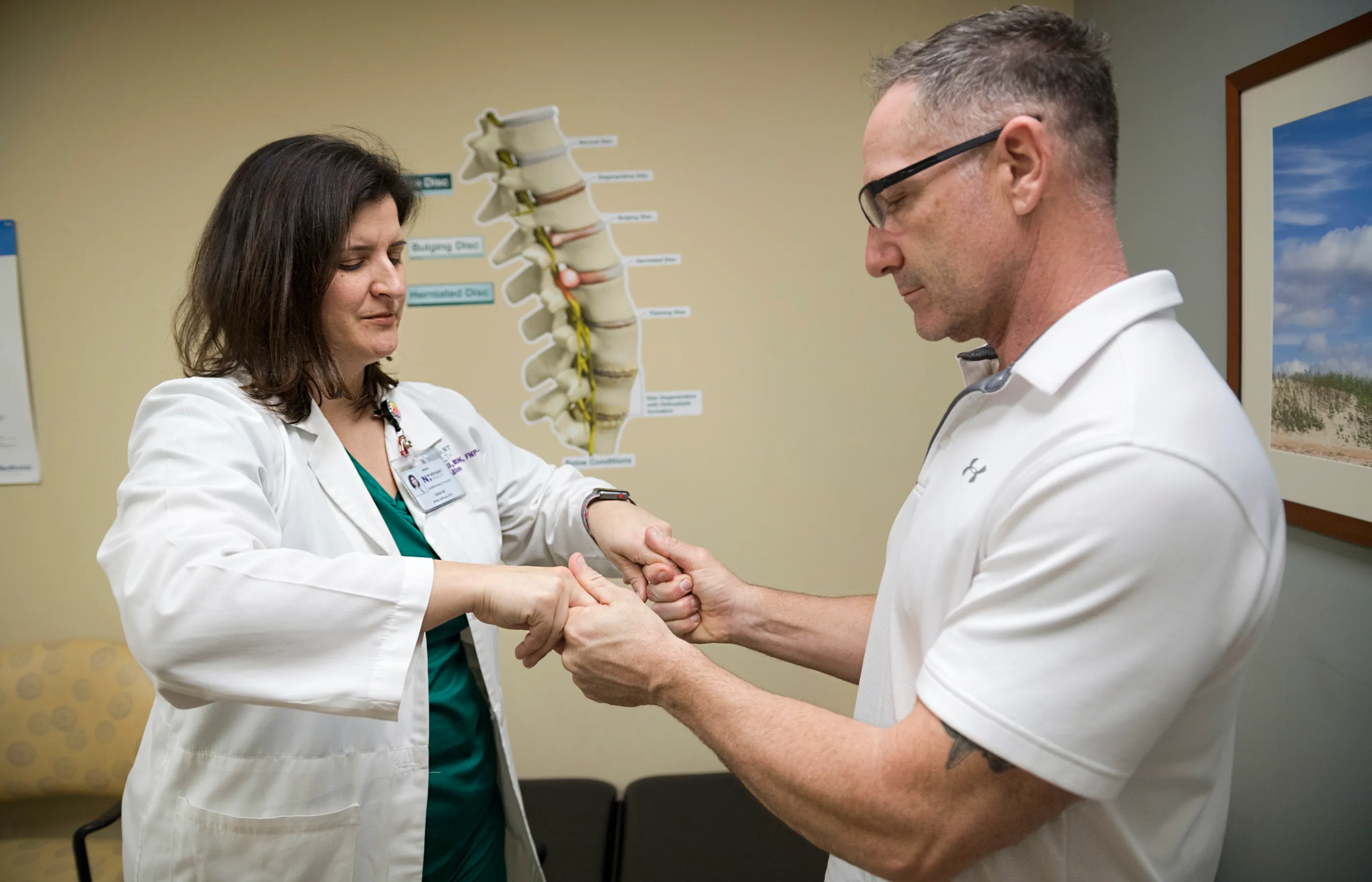 Dr. Mattioli is examining a patients hand grip. 