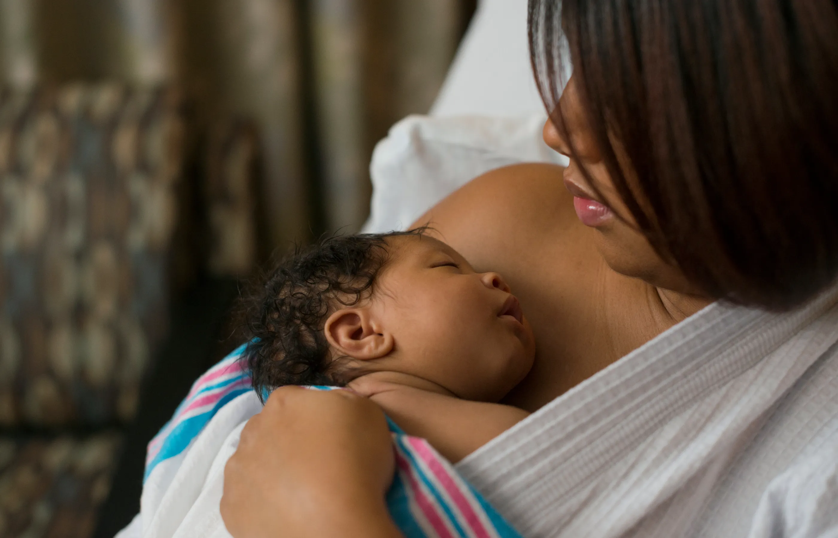 A mother with her newborn baby laying on her bare chest.  A mother with her newborn baby laying on her bare chest.