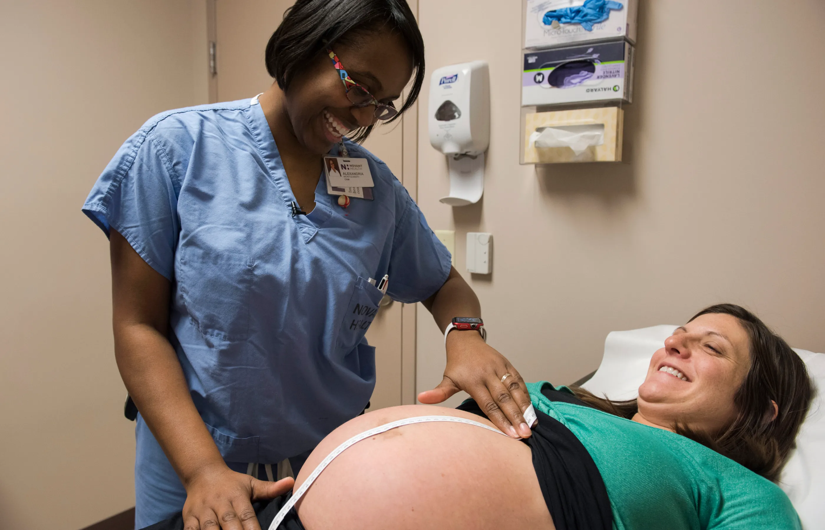 A Novant Health nurse is measuring the belly of a pregnany woman. 
