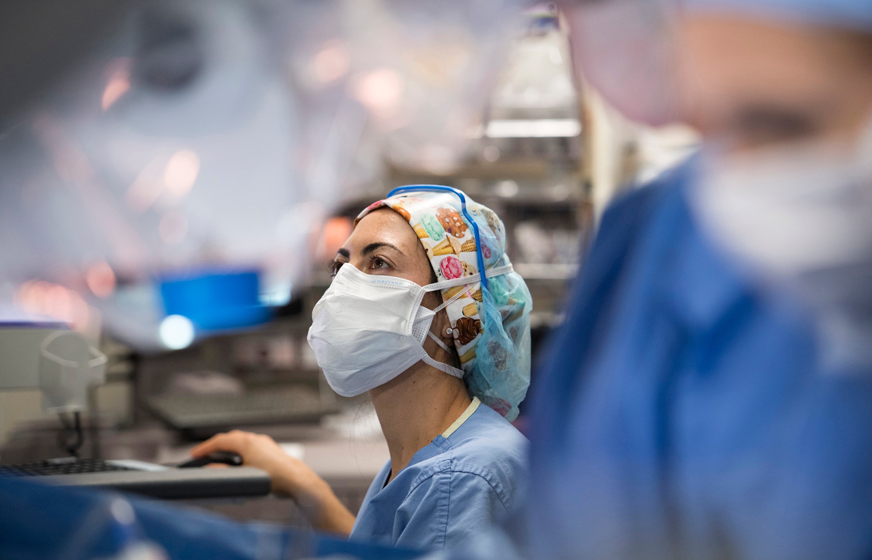 A Novant Health nurse is sitting in an operating room documenting information on a computer. 