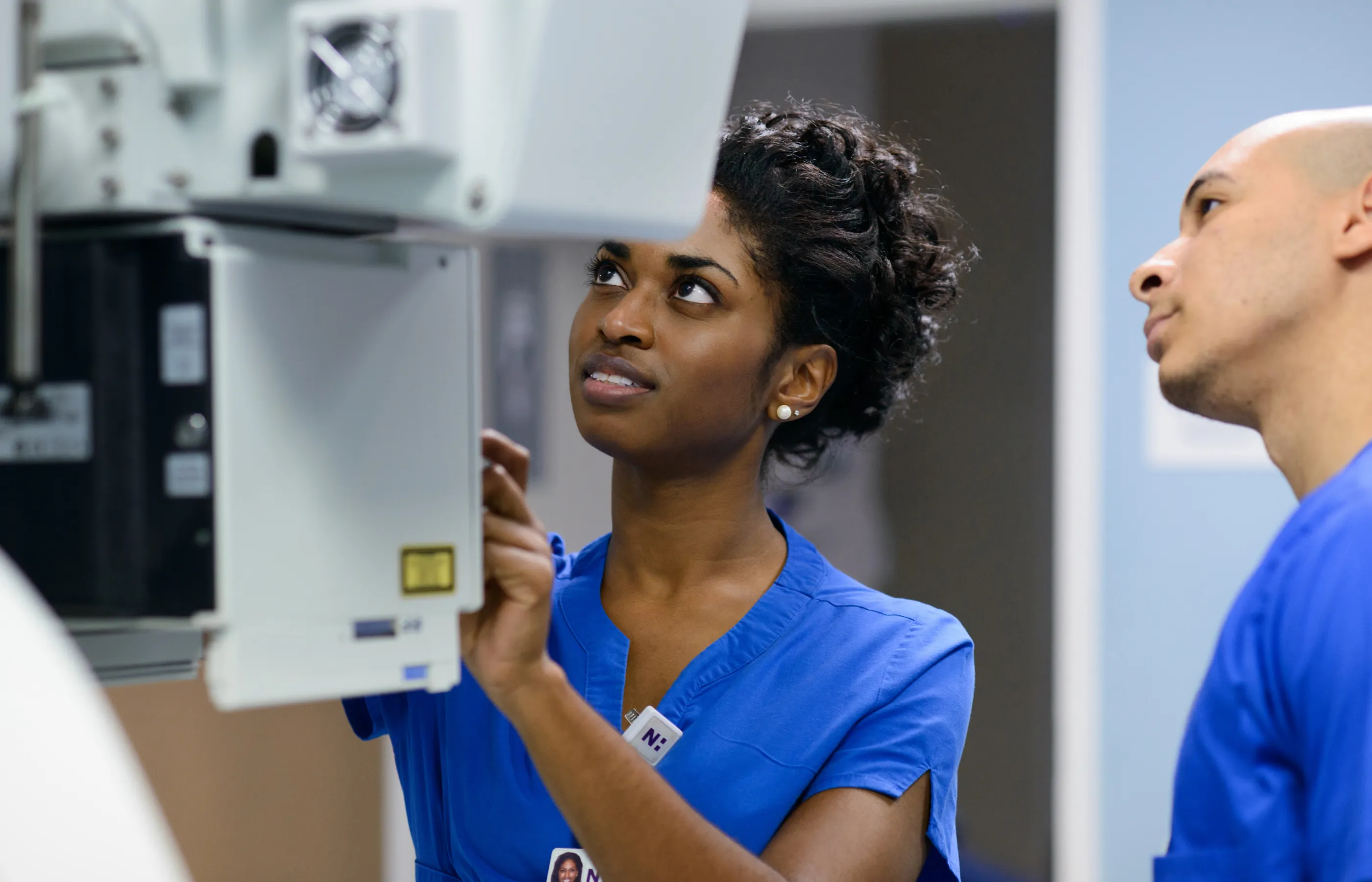 A Novant Health team member is operating a machine to capture an patients imaging scan. 