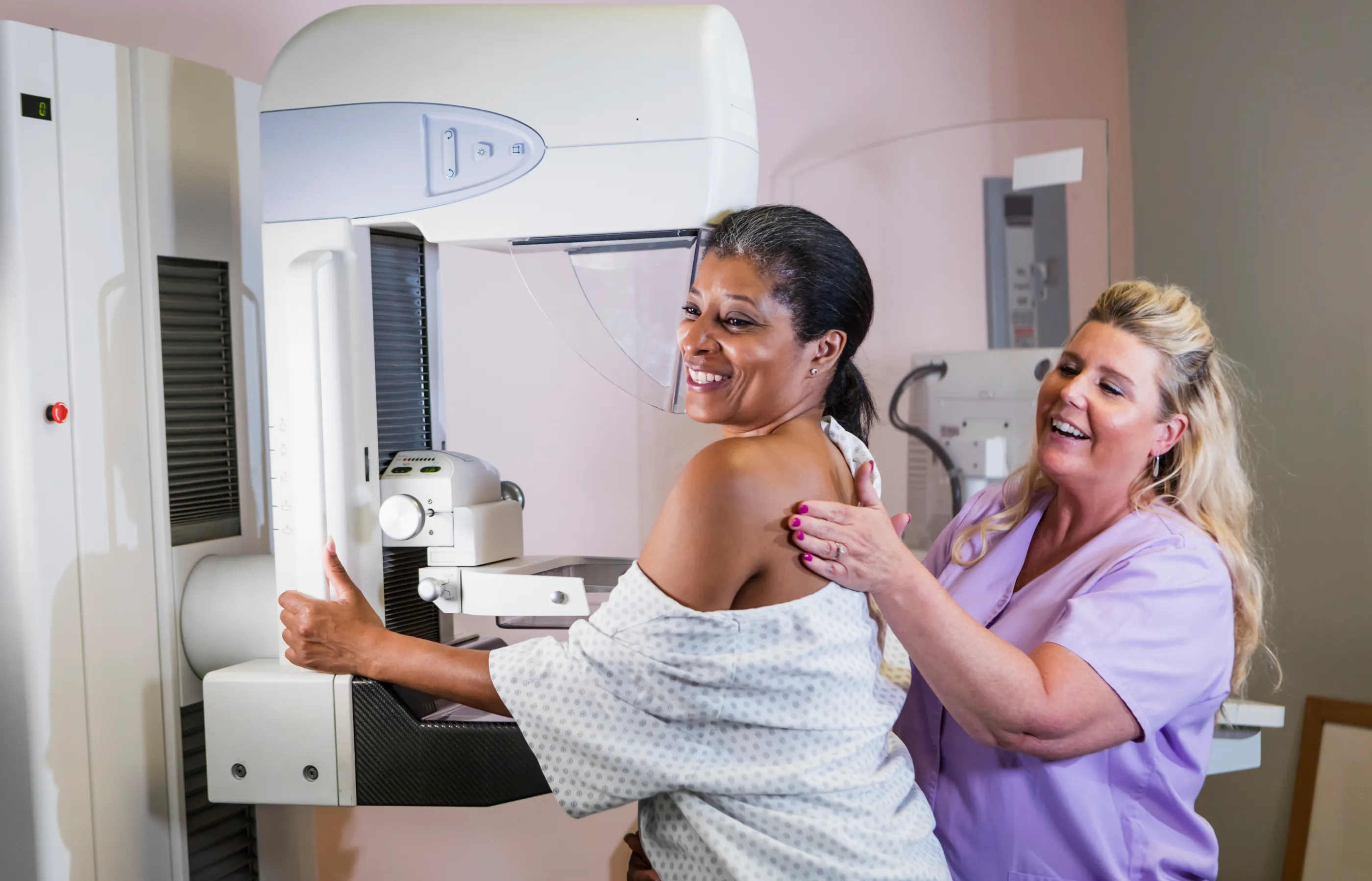A nurse is assisting a woman who is preparing for a mammogram.  A nurse is assisting a woman who is preparing for a mammogram.