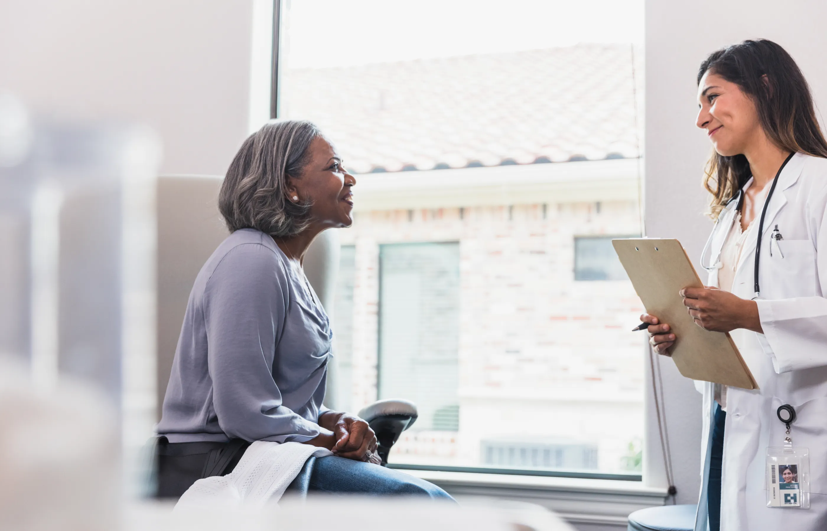 Senior woman meeting with a provider in a clinical exam room.