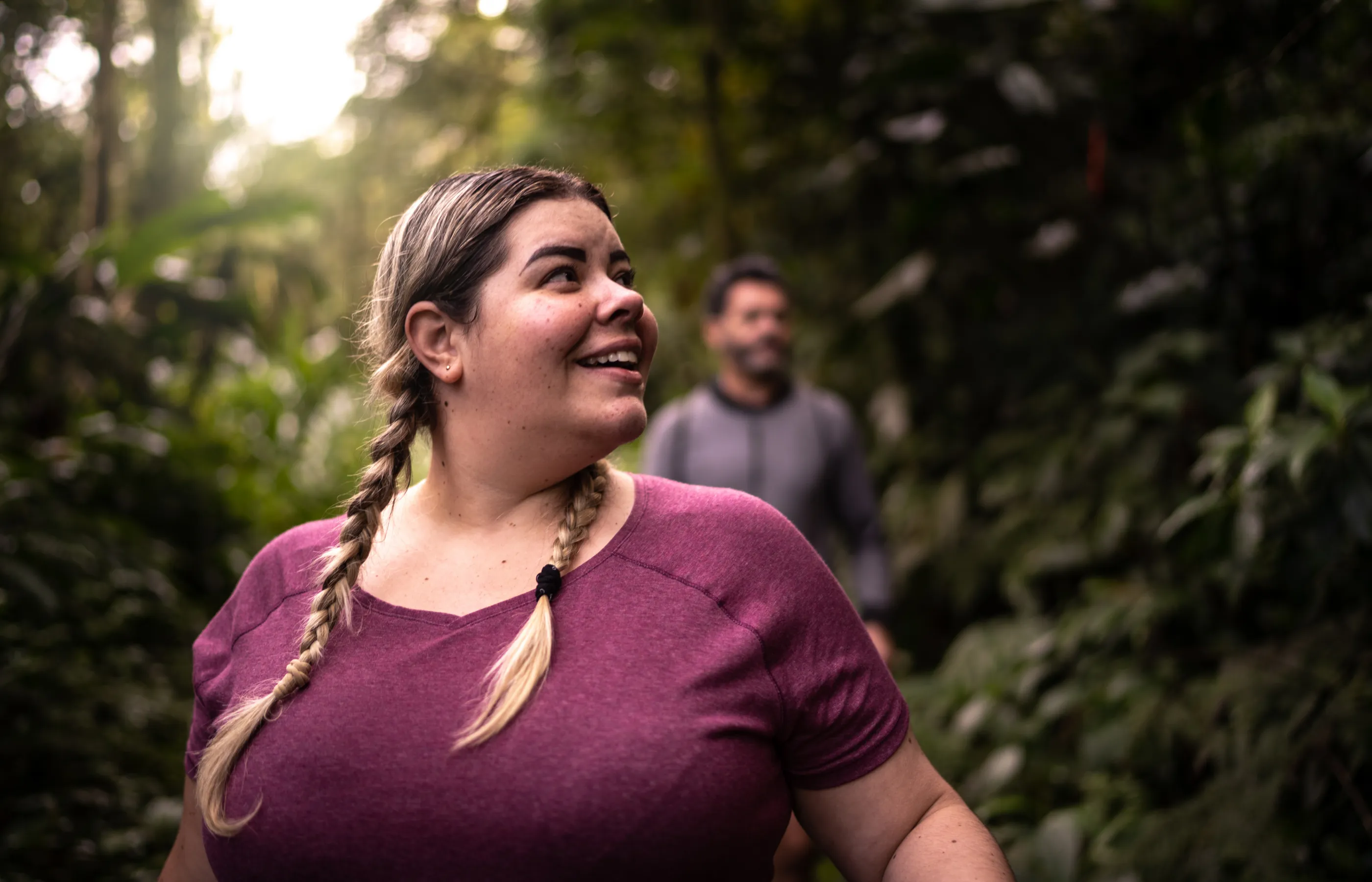 A plus size woman is out hiking with her partner. 