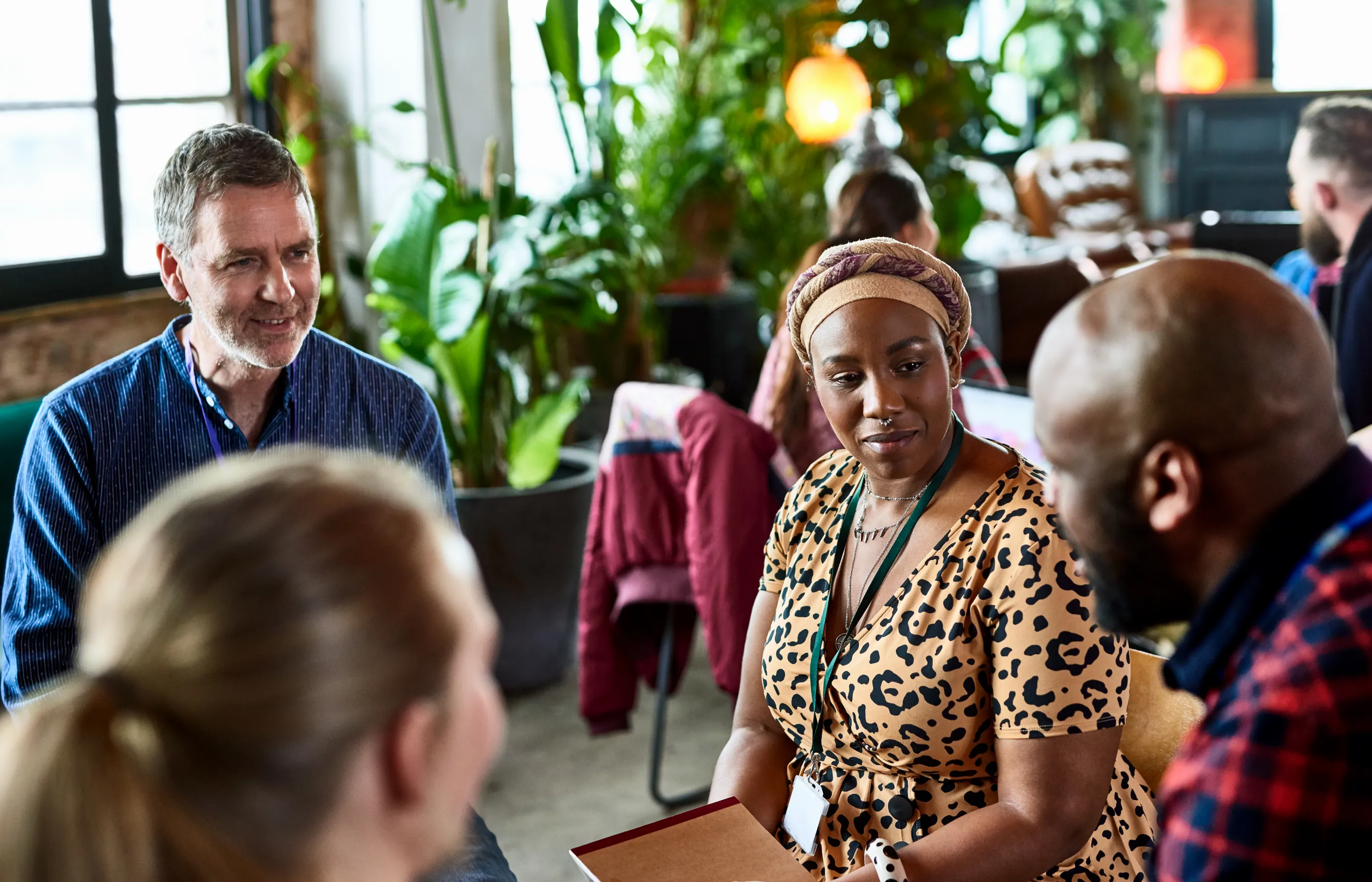 Many groups of people are sitting around in circles talking with each other.  Many groups of people are sitting around in circles talking with each other.