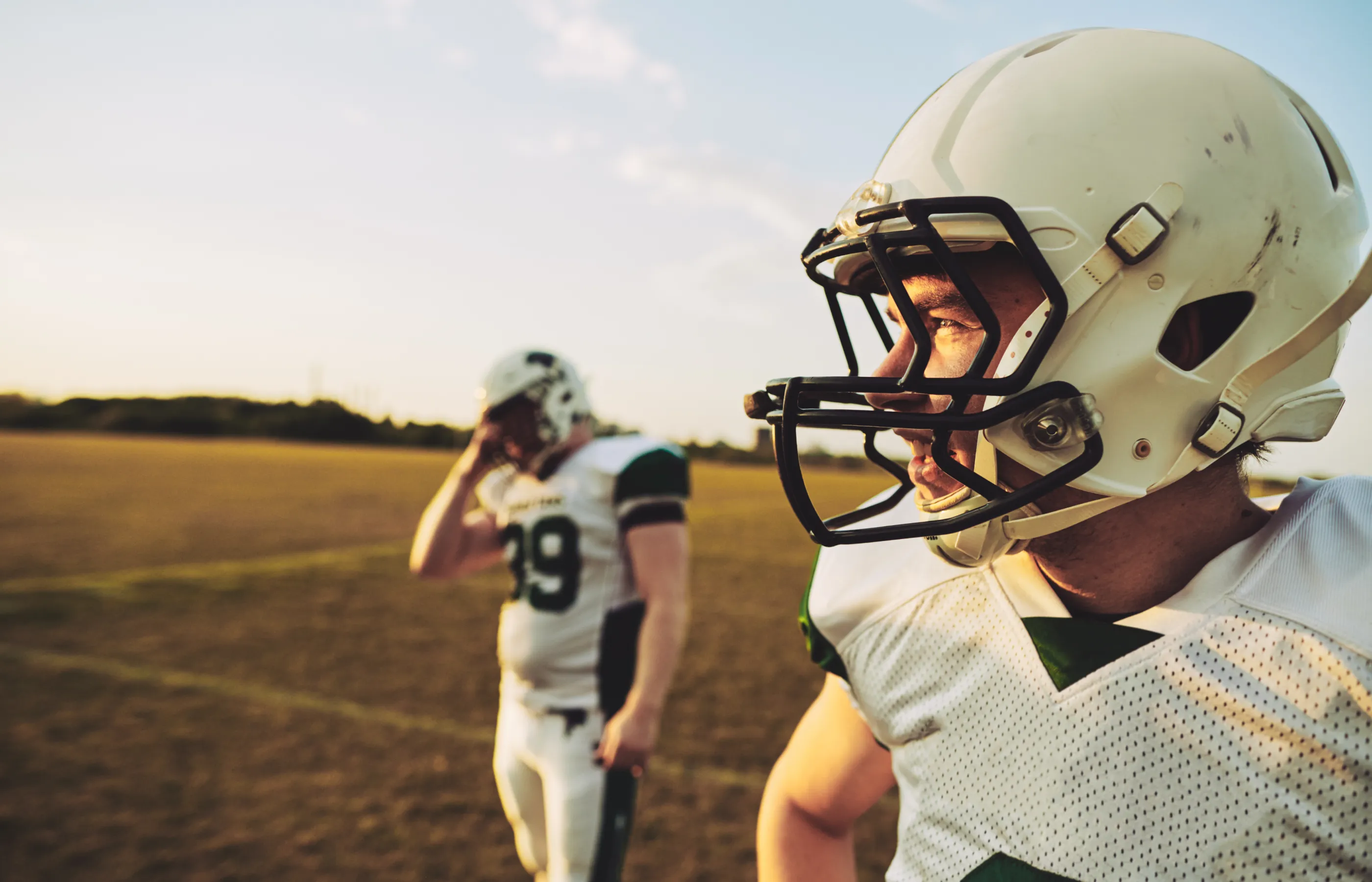 Two young American Football Players looking towards the end zone