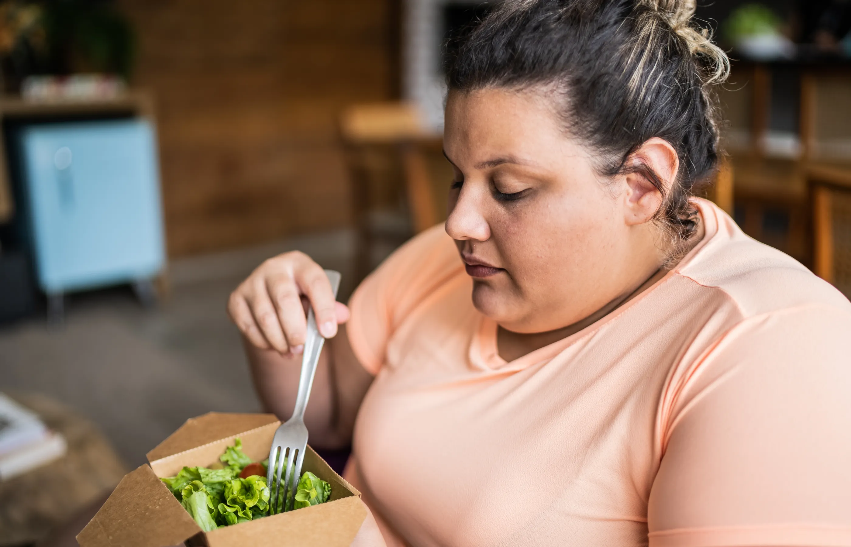 A woman is eating a salad. 