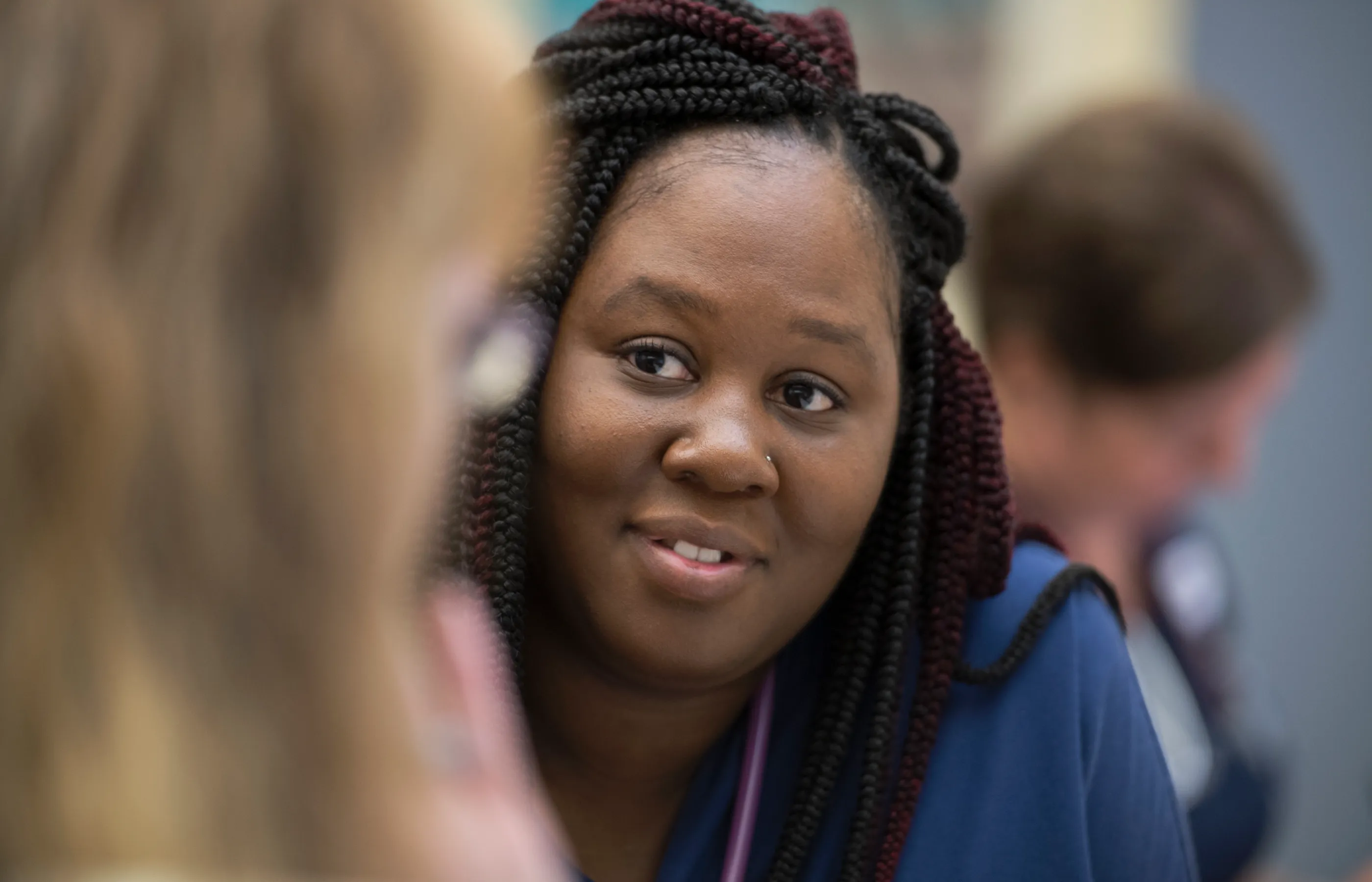 A Novant Health team member is sitting and talking with another team member. 