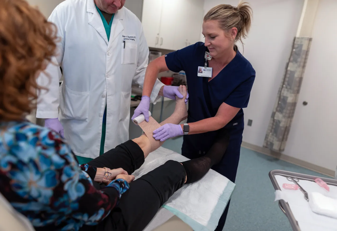 Doctor and nurse wrapping a patient's leg and foot wound. 