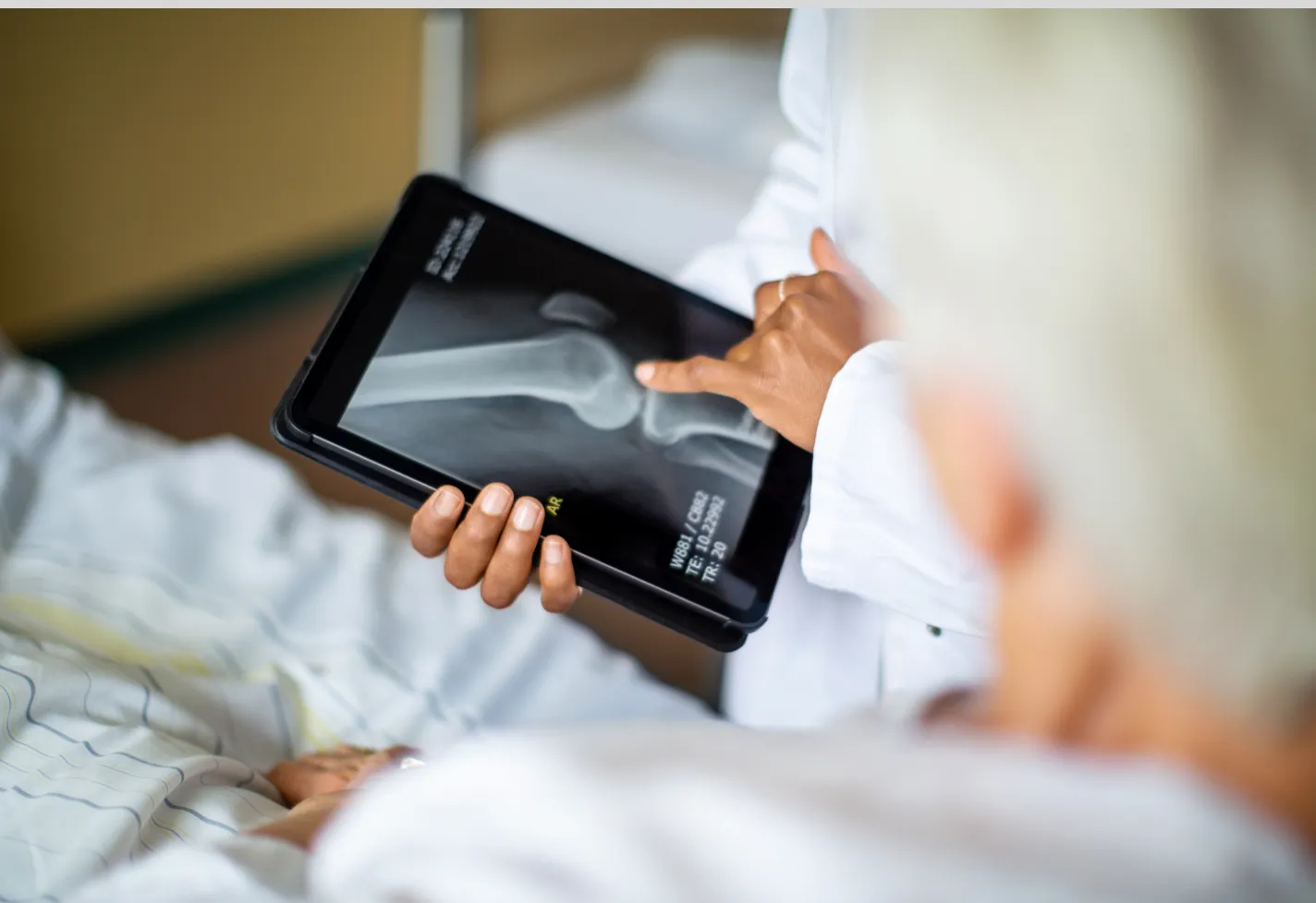 A health care provider is reviewing an x-ray on a smart tablet. 