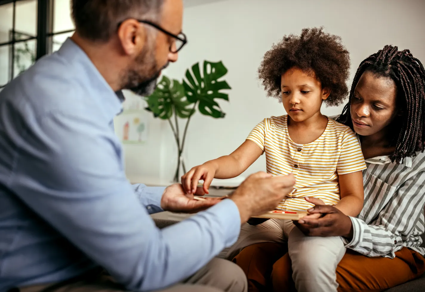 Mother having a therapy session for her daughter with male psychologist